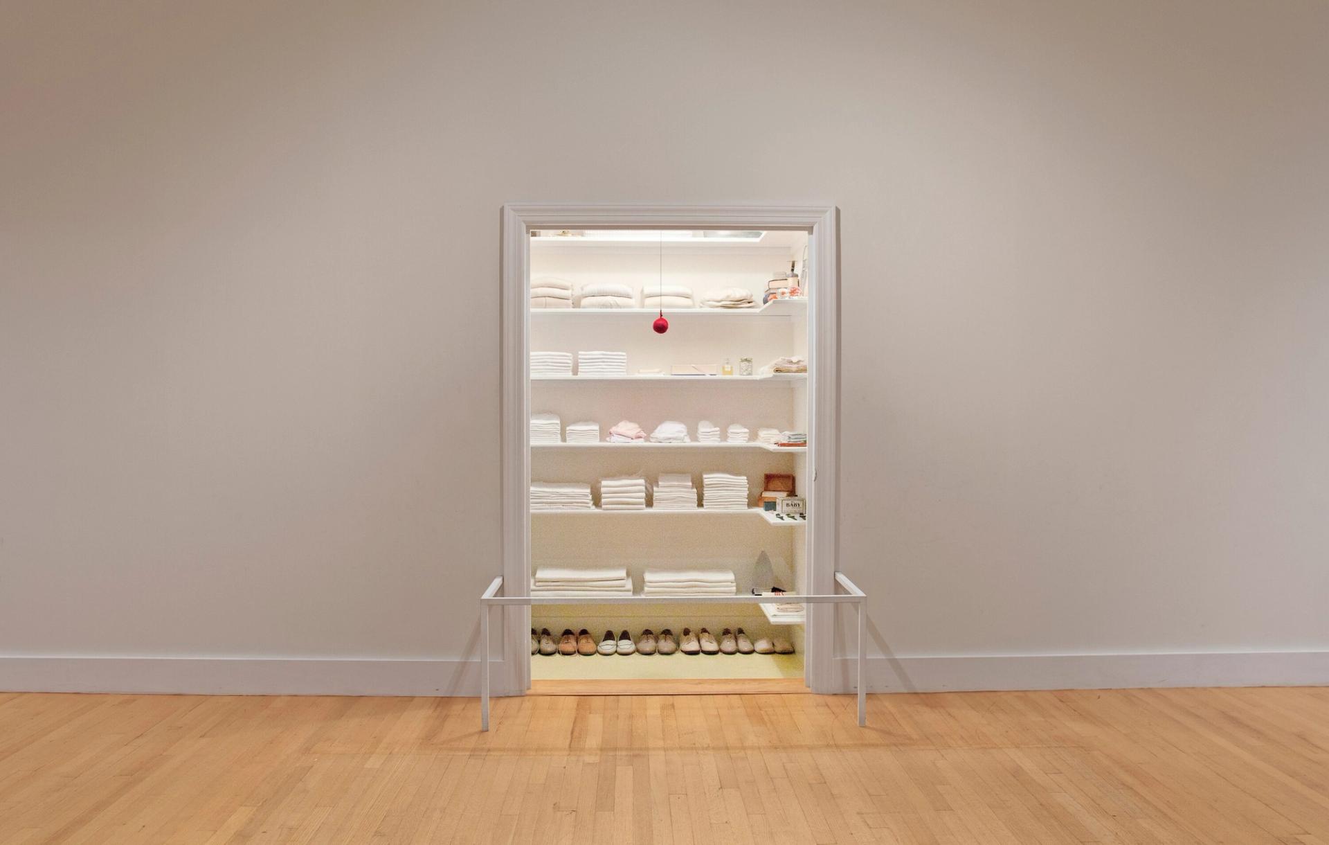 Walk in closet with white folded clothing