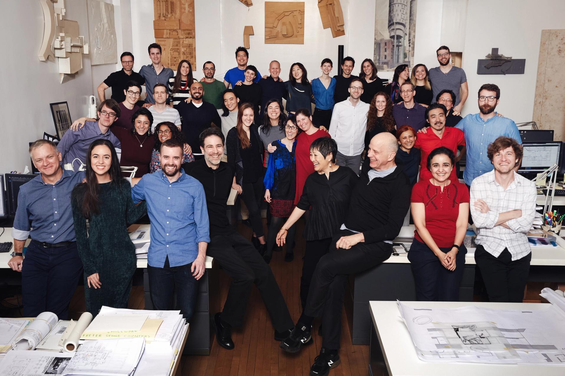 Many people indoors at an architecture firm in New York.