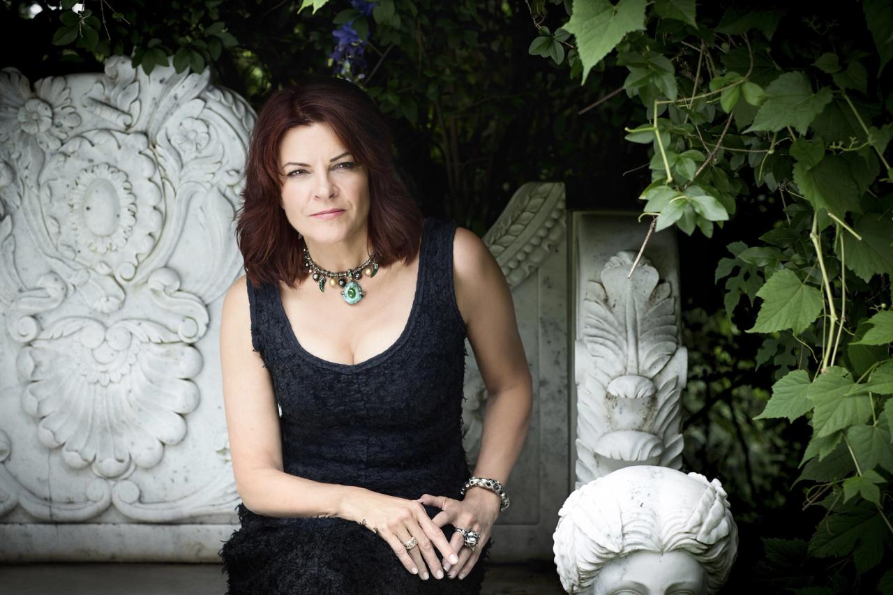 Singer and songwriter Rosanne Cash sitting next to a treee