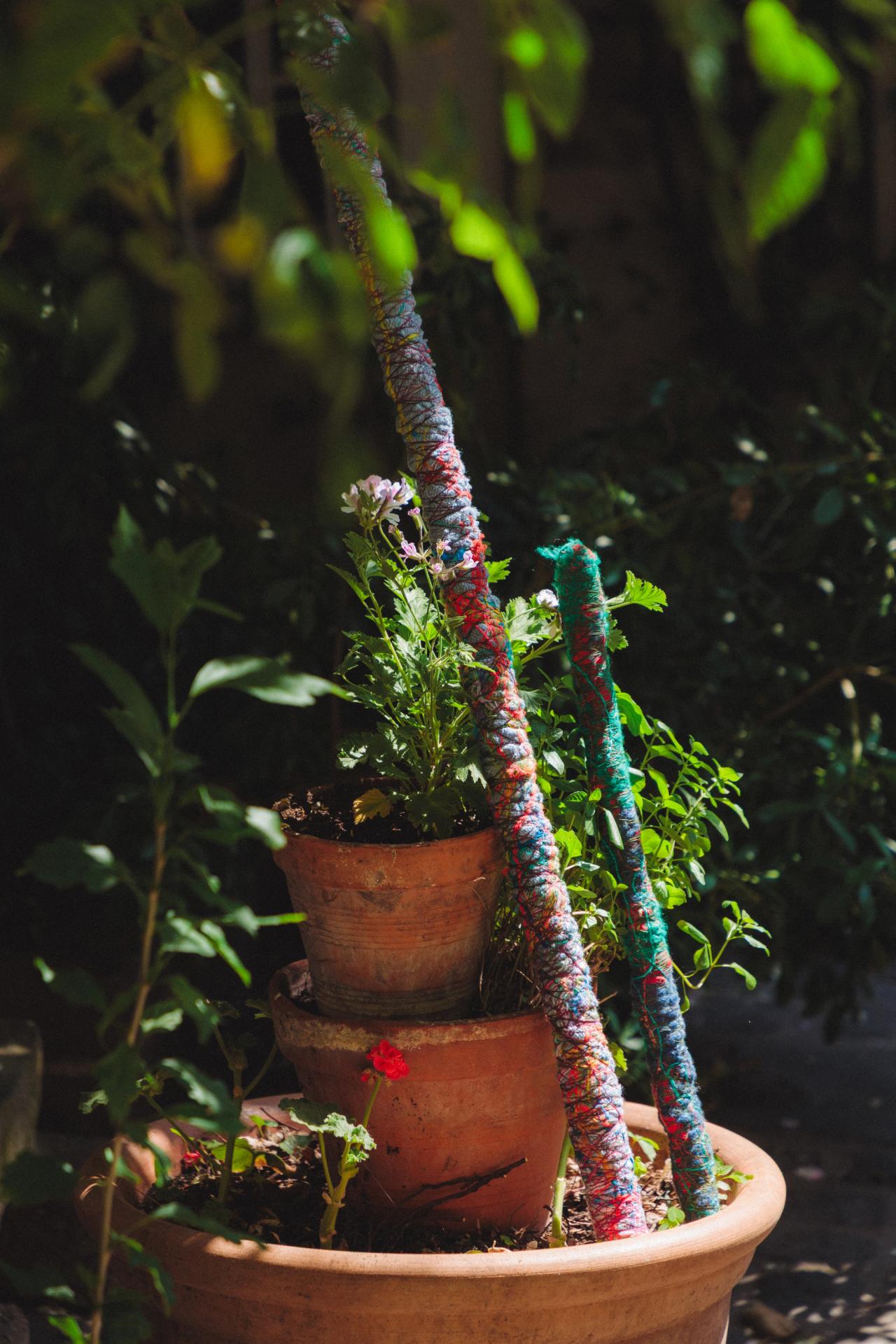 Planters inside Hicks’s courtyard in Paris, with two sticks of her creation wrapped in fabric and thread leaning against them. (Photo: Agathe Karsenti for The Slowdown)