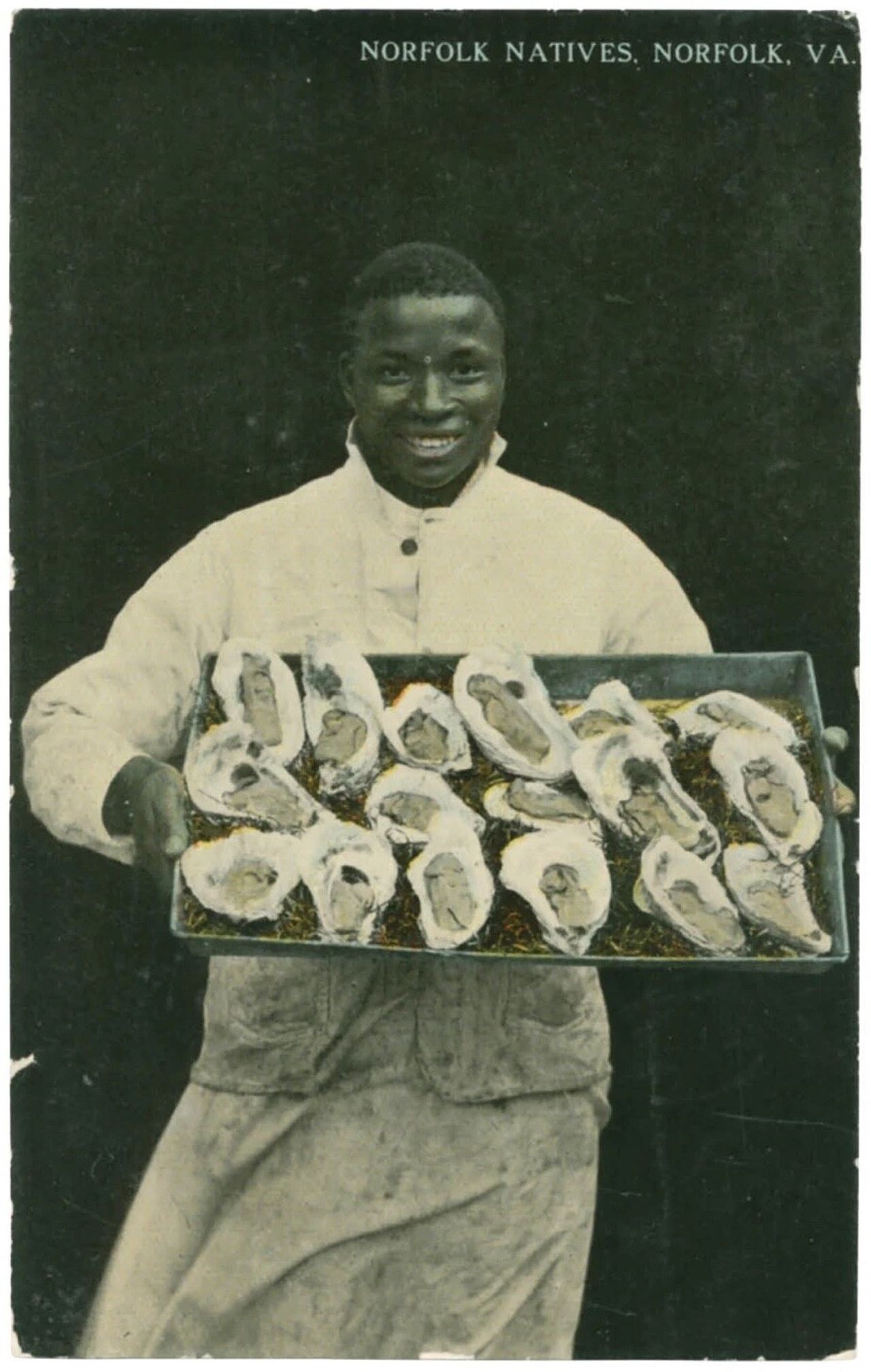 A postcard depicting a native of Norfolk, Virginia, carrying a tray of oysters, as featured in Vintage Postcards from the African World (2020) by Jessica B. Harris. (Courtesy the University Press of Mississippi)