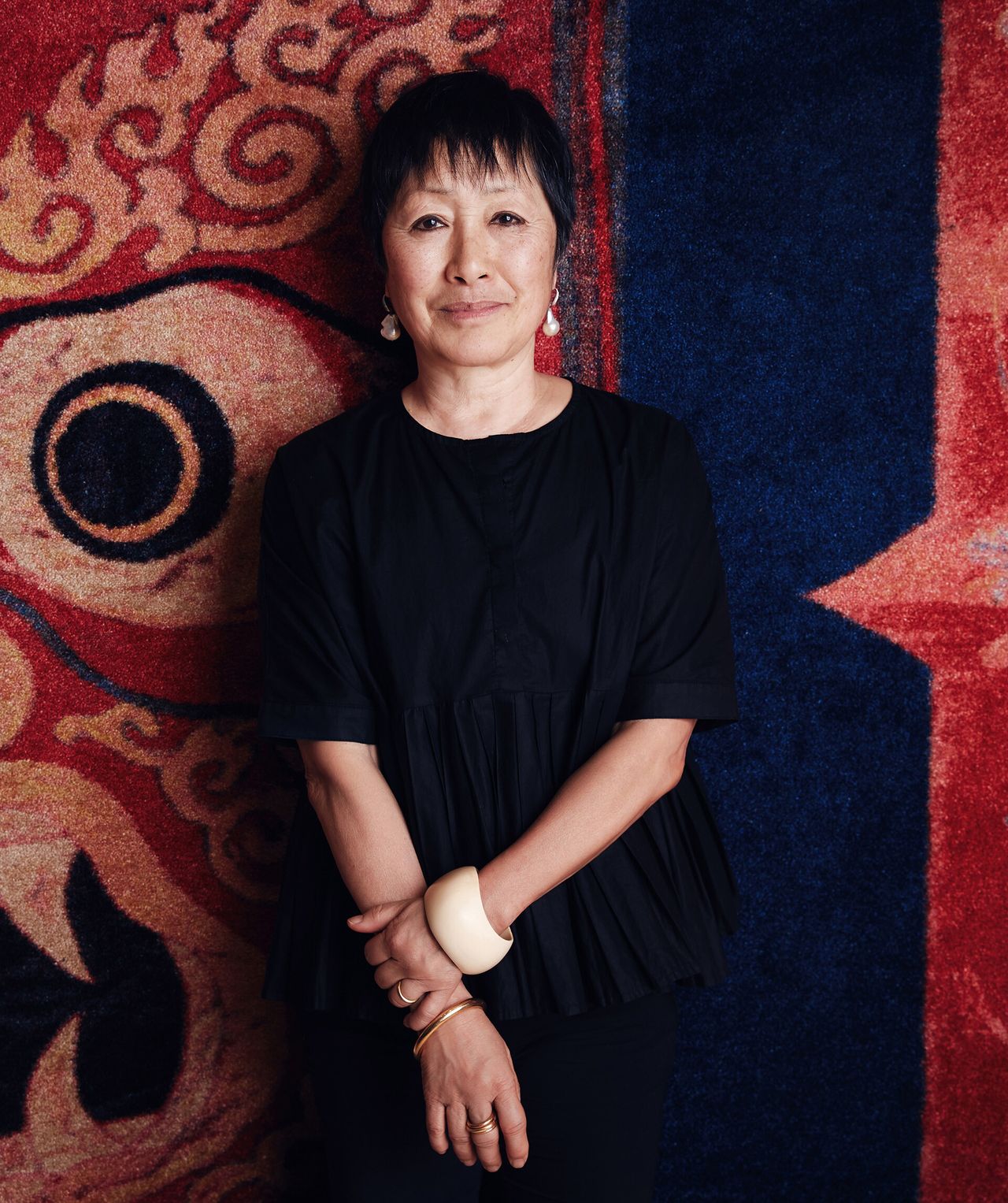 Architect Billie Tsien standing in front of tapestry