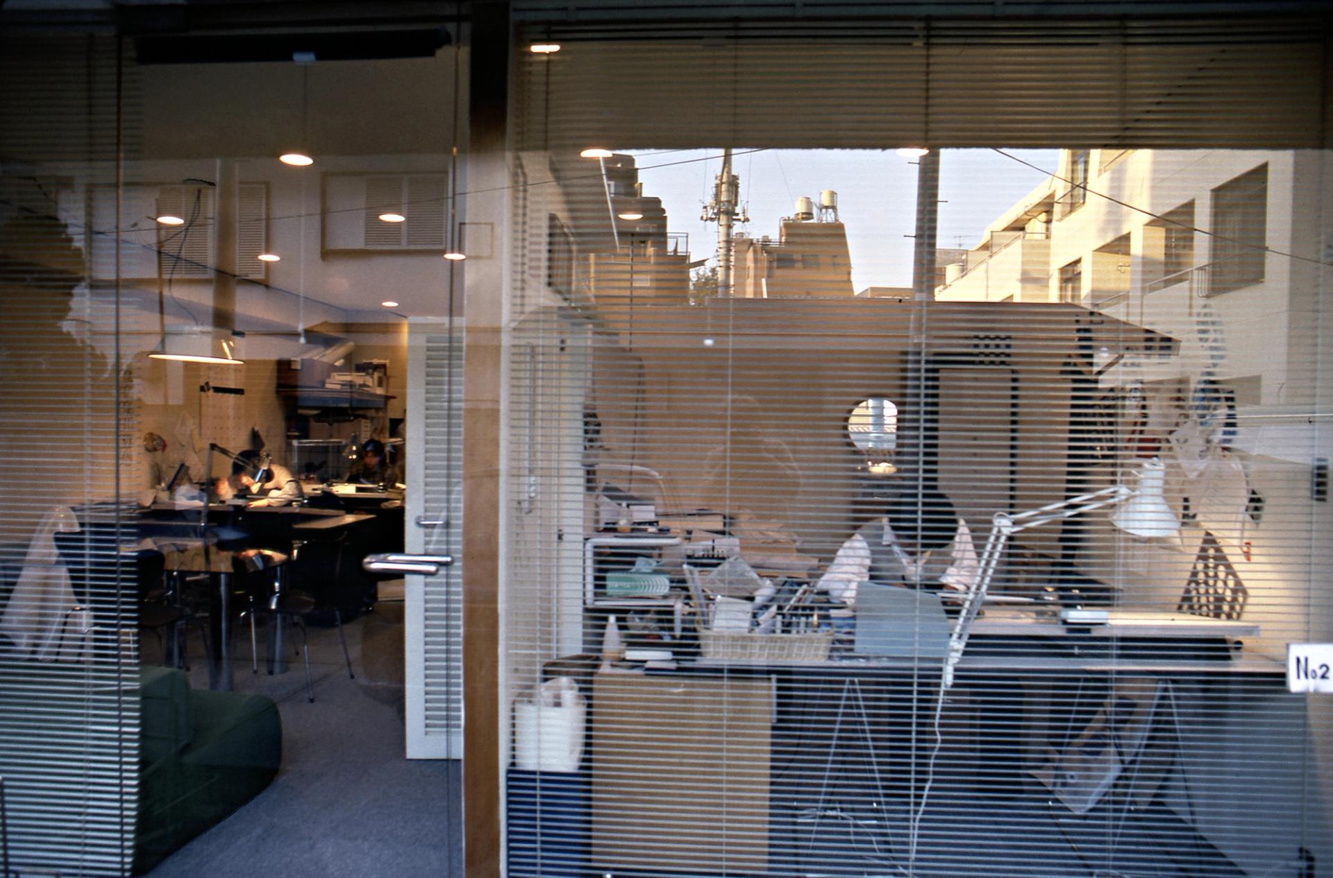 Designer Shiro Kuramata in his office, with Pawson’s reflection in the glass. (Courtesy John Pawson)