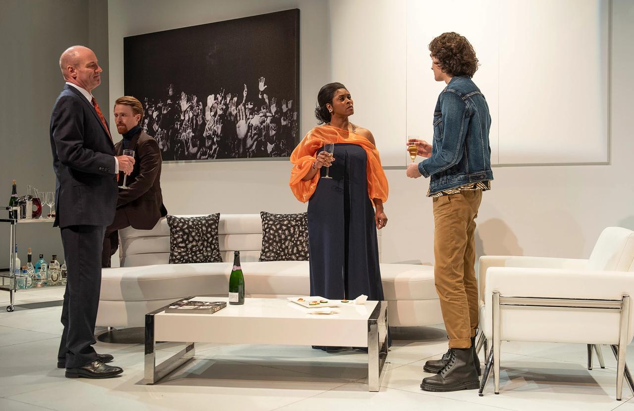 A scene from Rankine’s play The White Card. Actors from left to right: Tom Wahl, Iain Batchelor, Rita Cole, and Joshua Hernandez. (Photo: Magnus Stark. Courtesy GableStage)