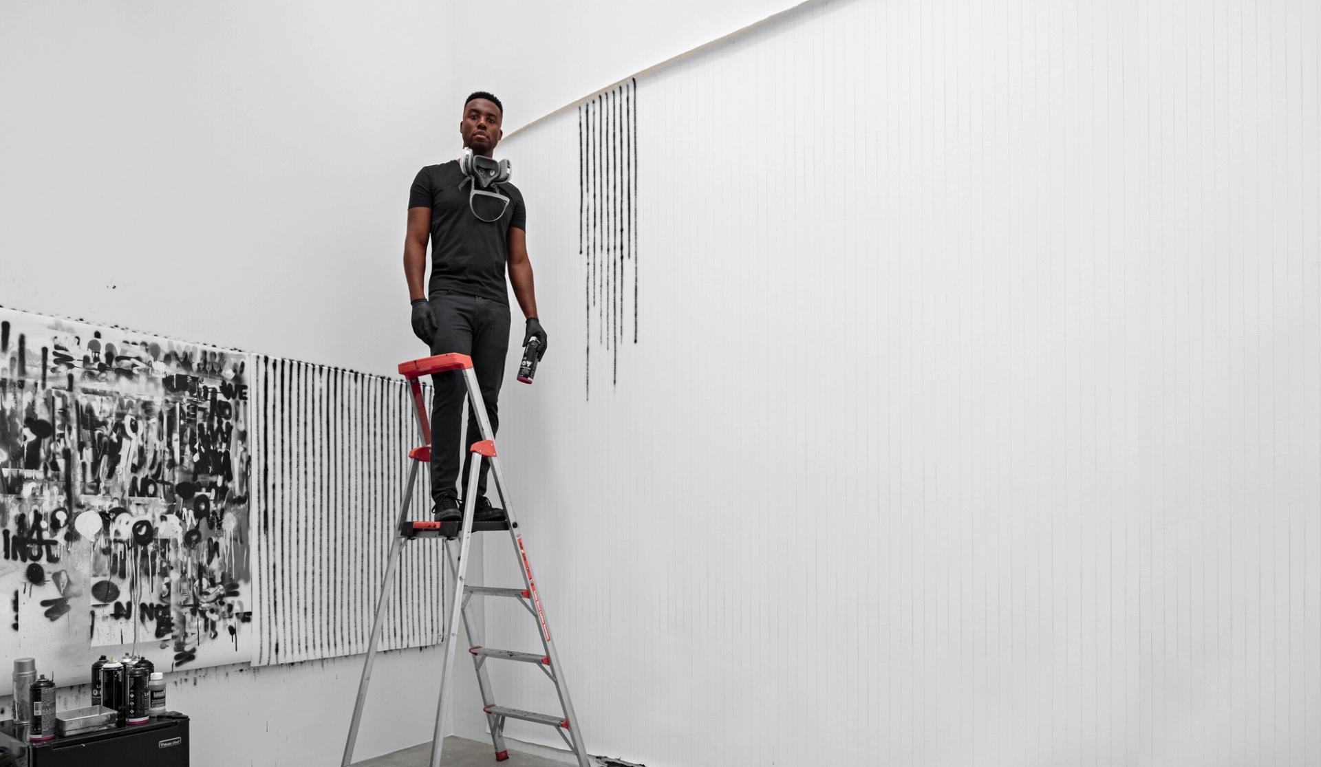 Pendleton in the process of creating a work with spray paint at Art Basel. (Photo: Matthew Placek)