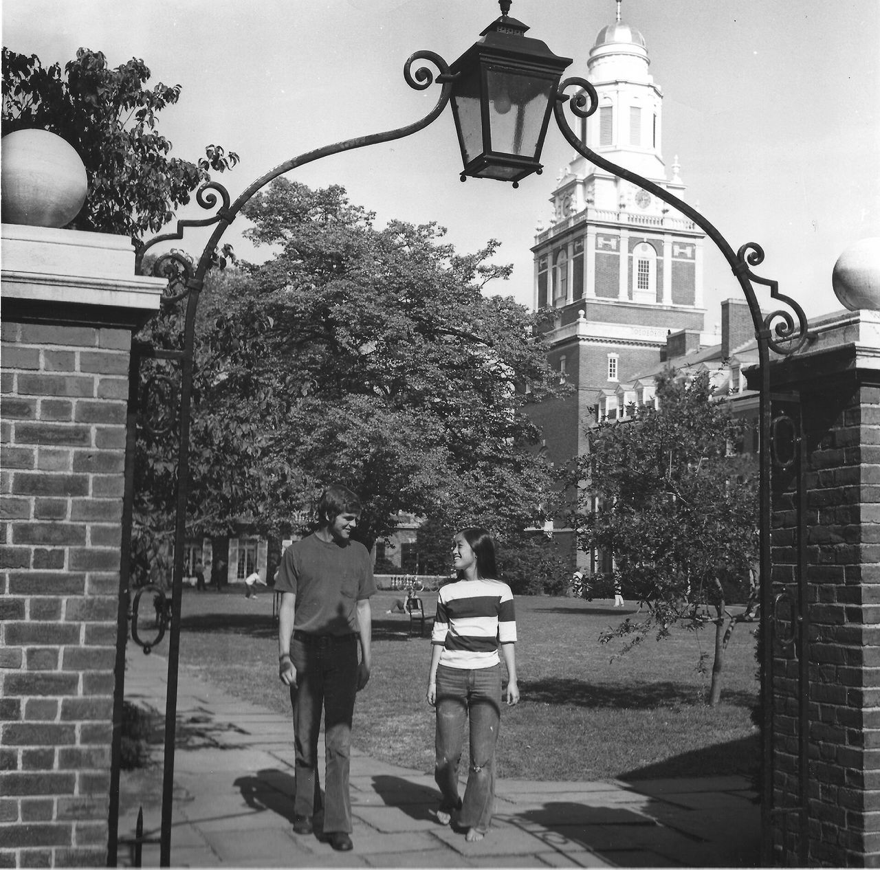 A man and woman walking beneath an archway outdoors