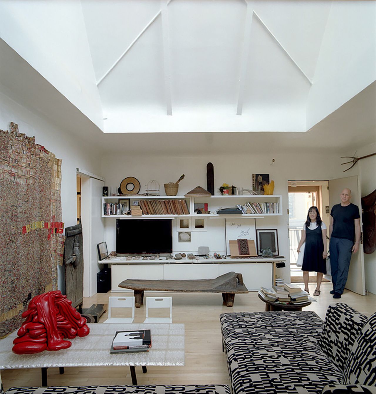 A couple walks inside their art-filled apartment