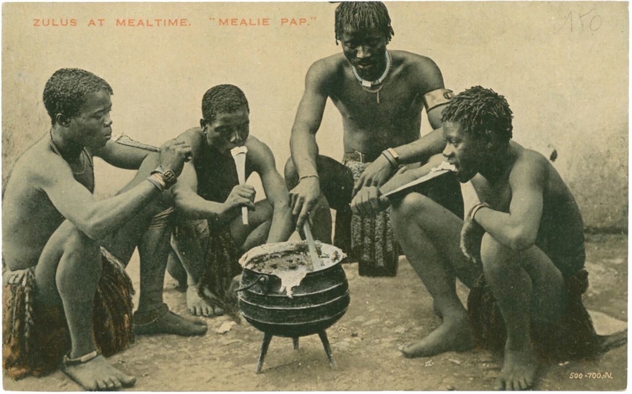 A postcard depicting Zulu men cooking, as featured in Vintage Postcards from the African World (2020) by Jessica B. Harris. (Courtesy the University Press of Mississippi)