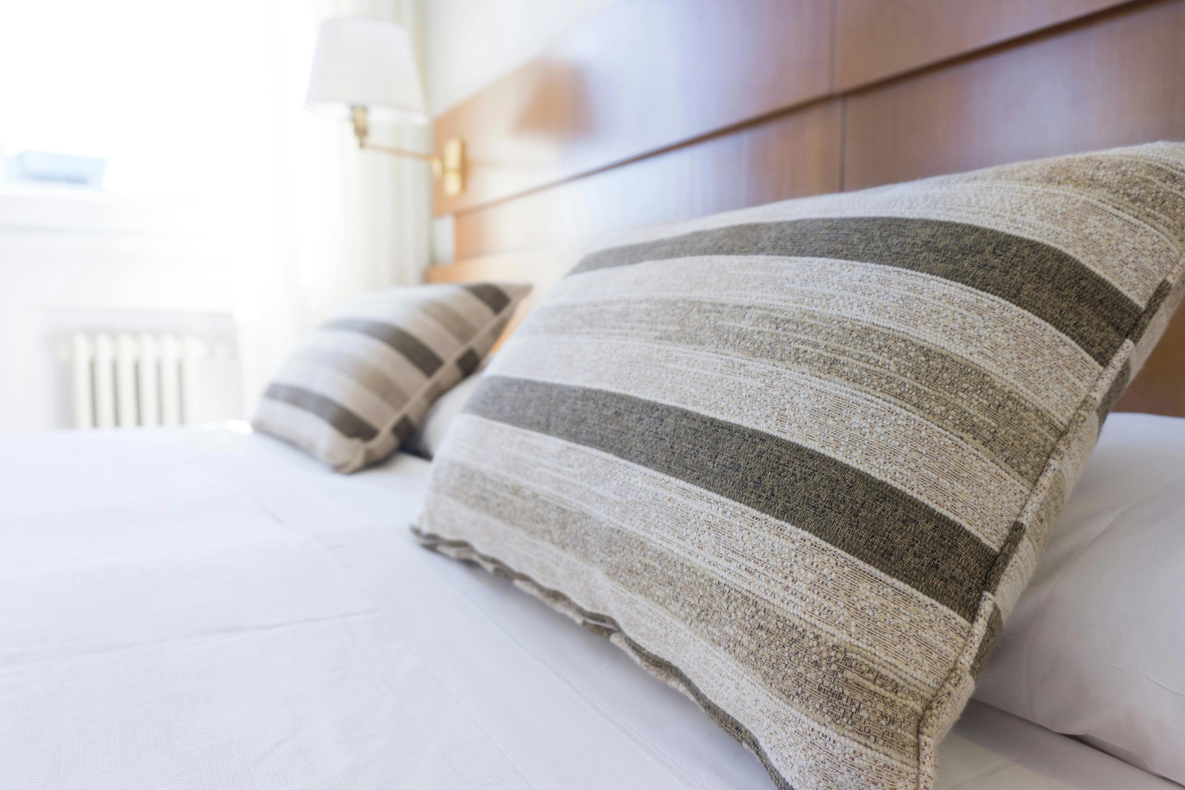 a bed with two pillows on it in a hotel room .