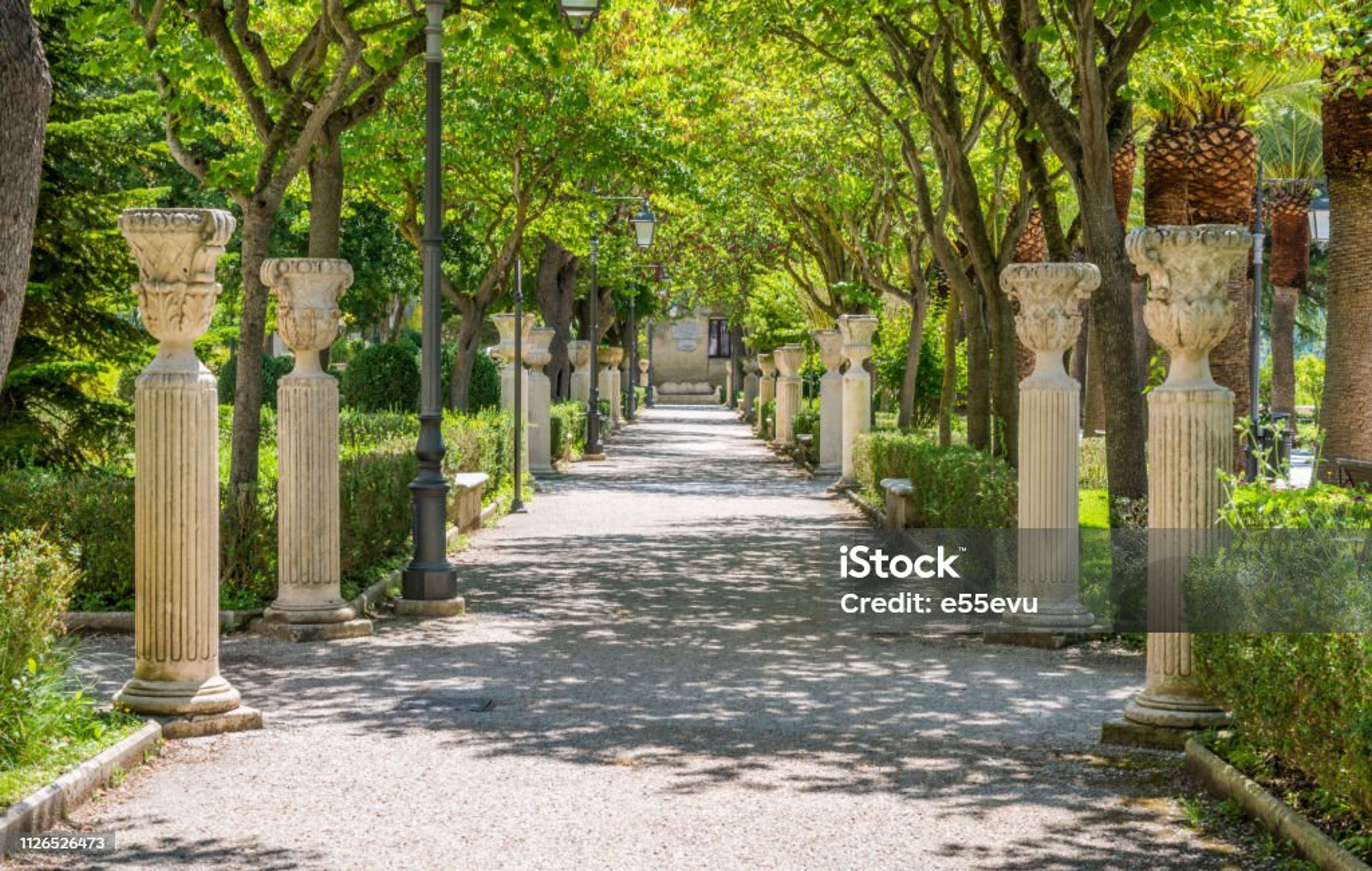 a row of columns and vases in a park .