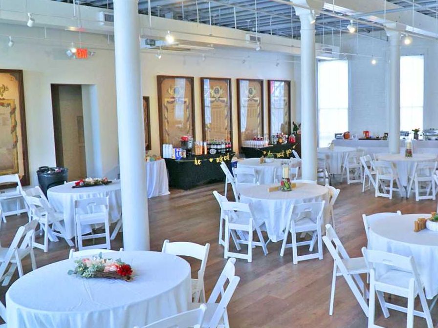 a large room with tables and chairs set up for a wedding reception .