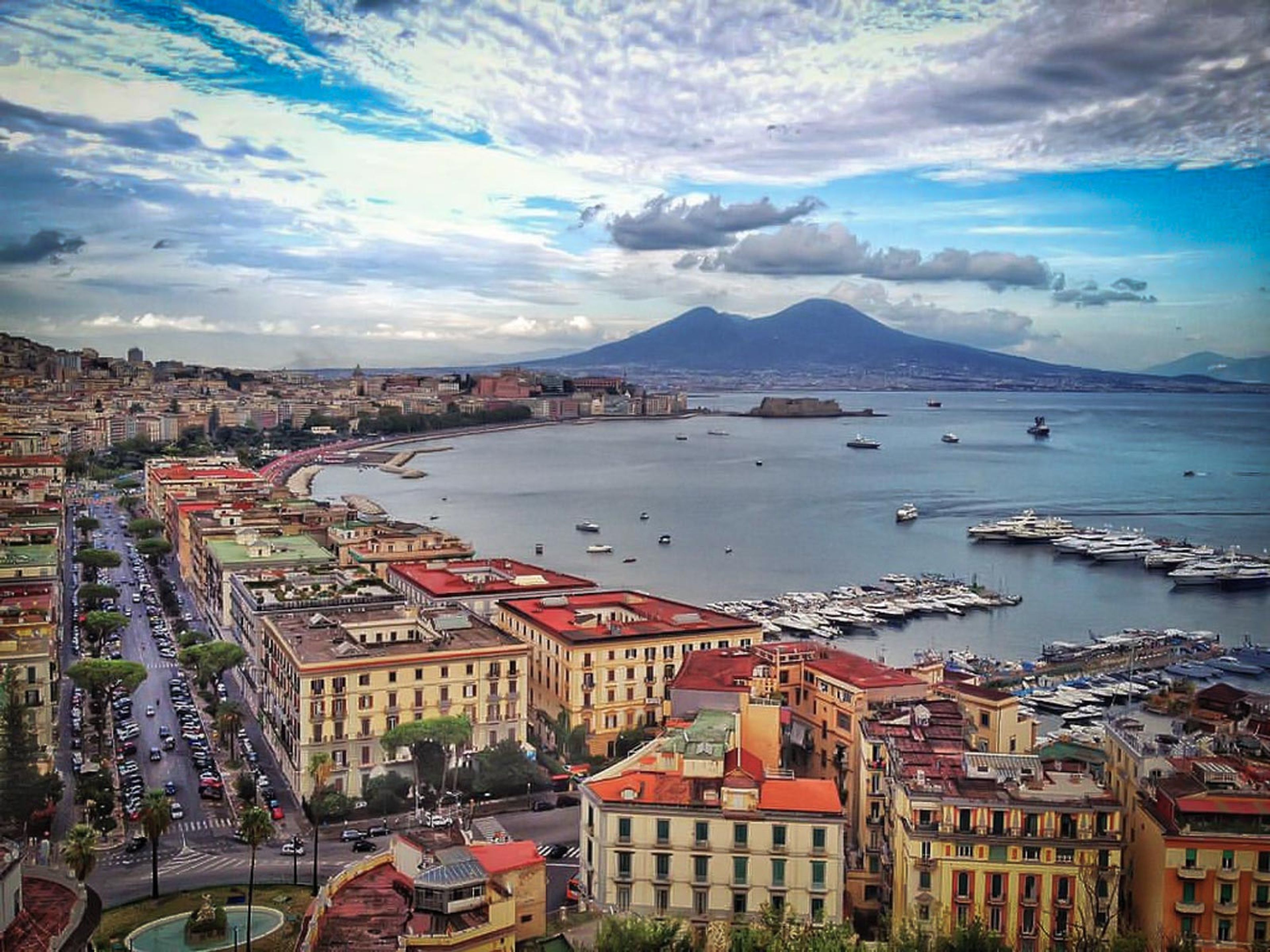 an aerial view of a city and a body of water with a mountain in the background .