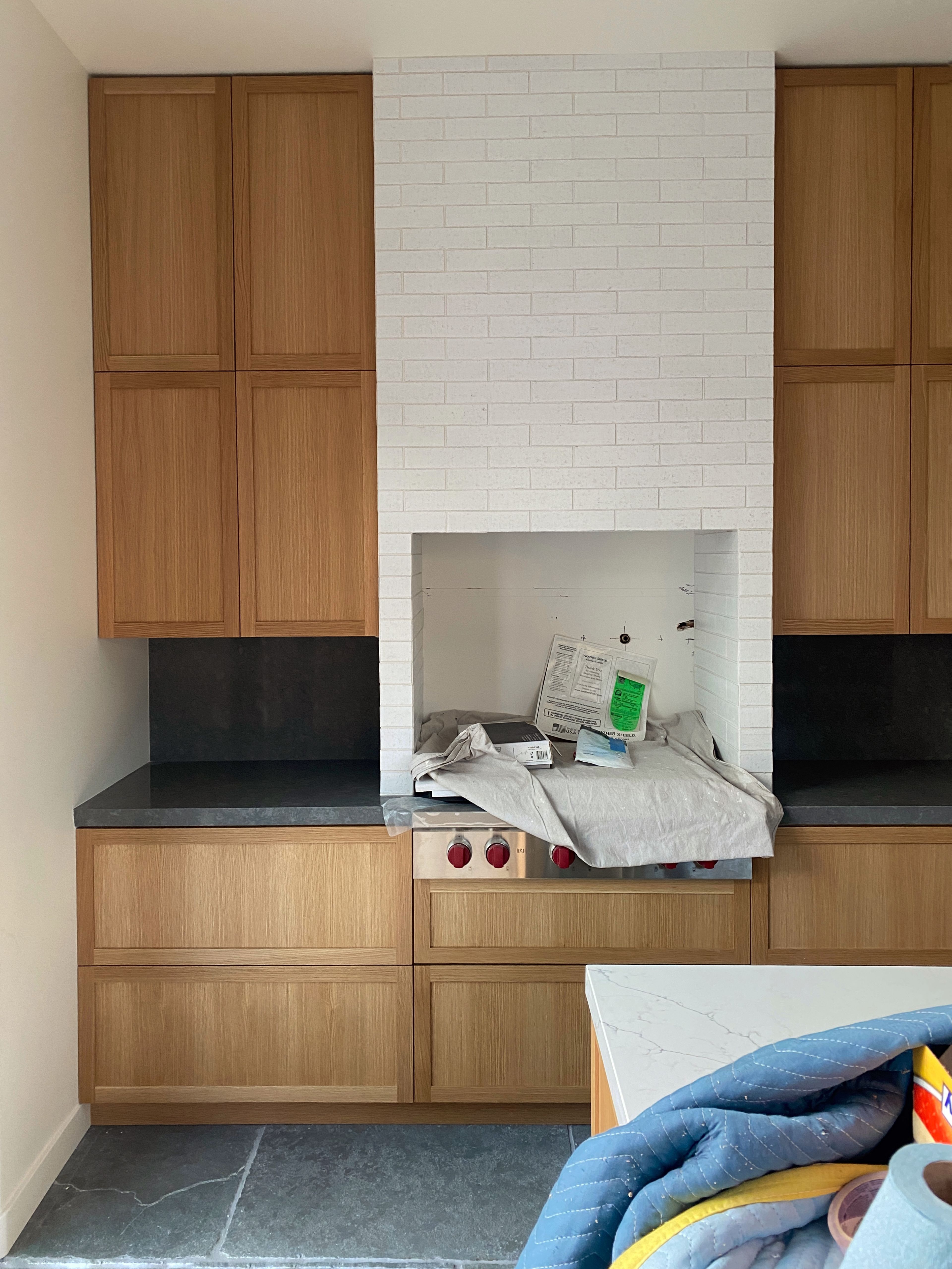 A built in range and hood clad in brick