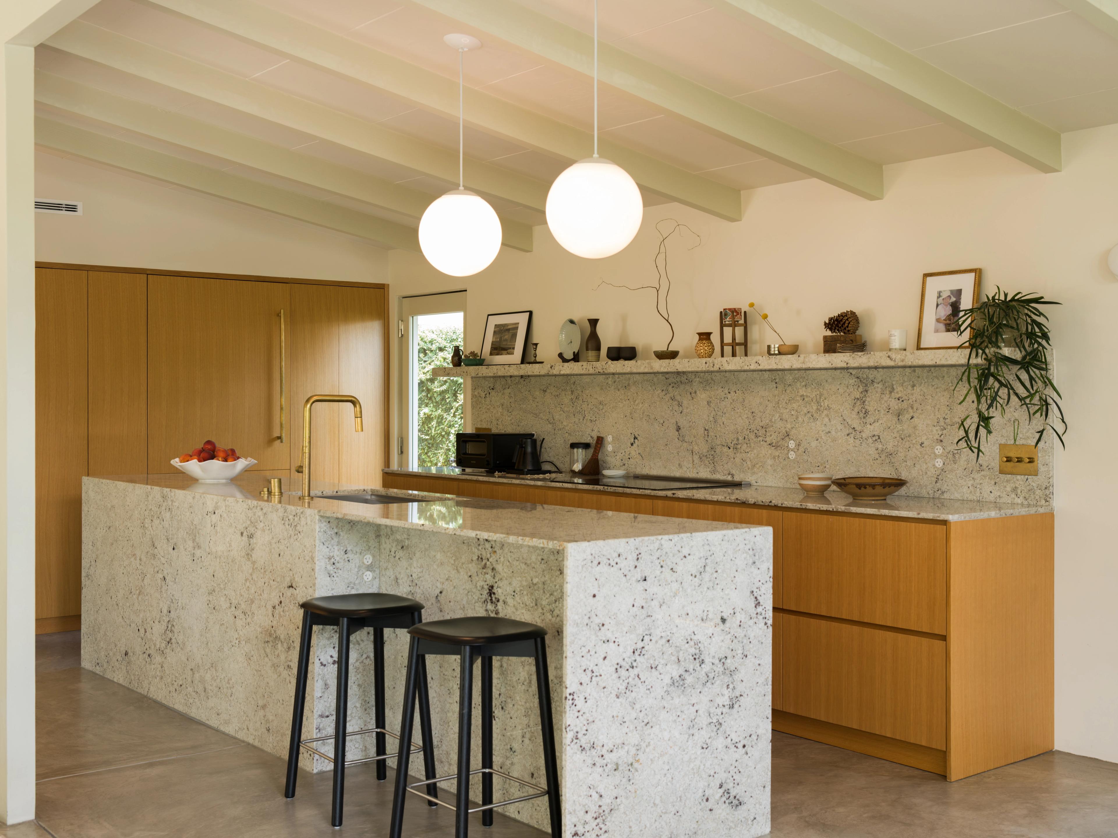 A granite kitchen island and seamless backsplash