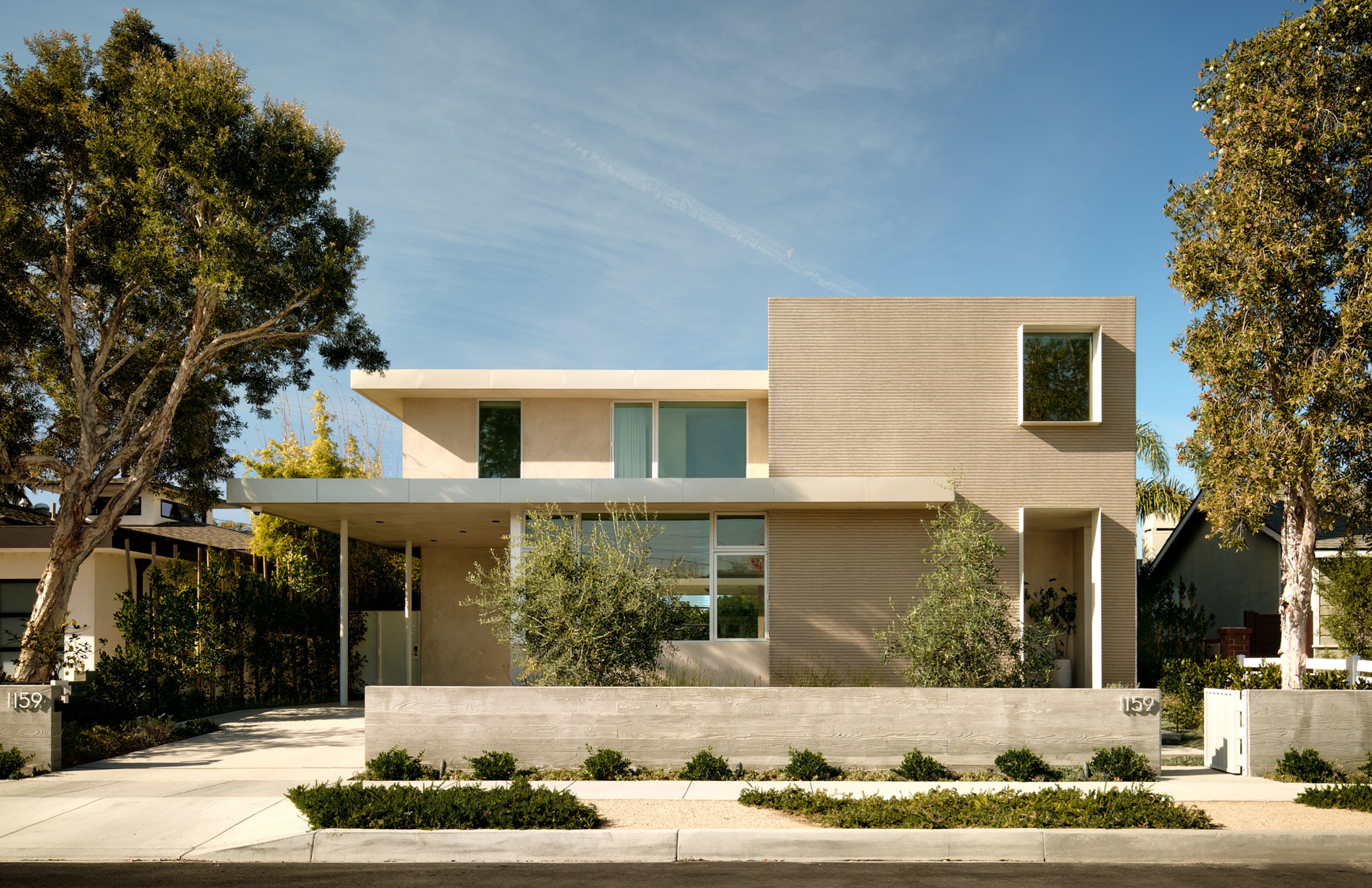 From the main street, the house appears as a low slung two-story contemporary home