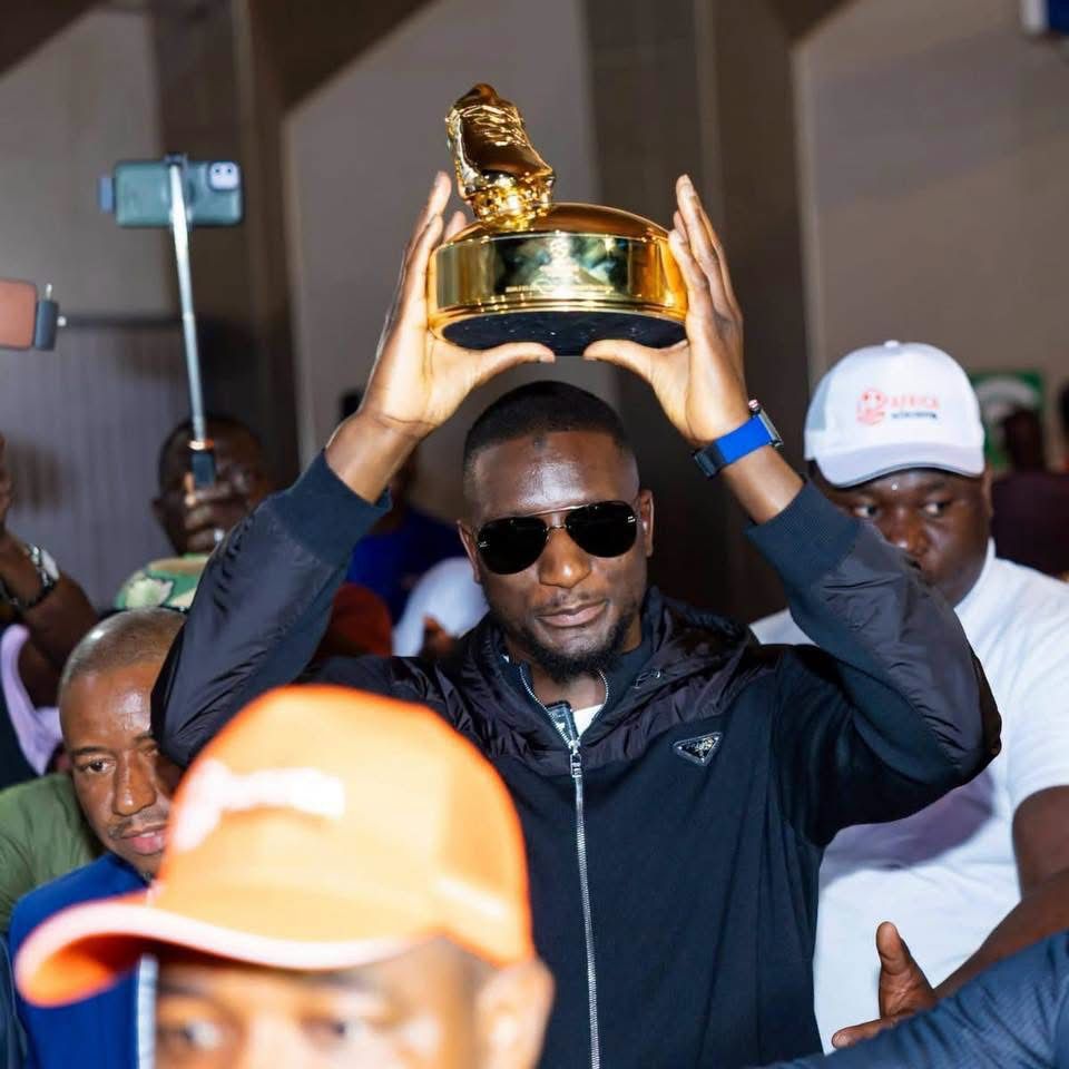 L'attaquant international guinéen Serhou Guirassy présente son trophée de meilleur buteur de la Ligue des Champions UEFA à son arrivée à l'aéroport de Conakry.