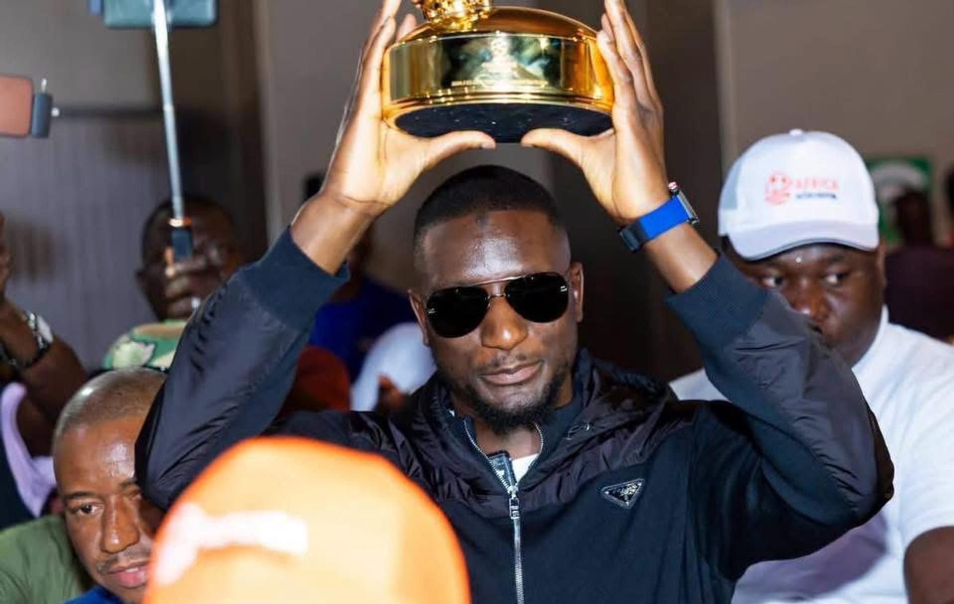 L'attaquant international guinéen Serhou Guirassy présente son trophée de meilleur buteur de la Ligue des Champions UEFA à son arrivée à l'aéroport de Conakry.
