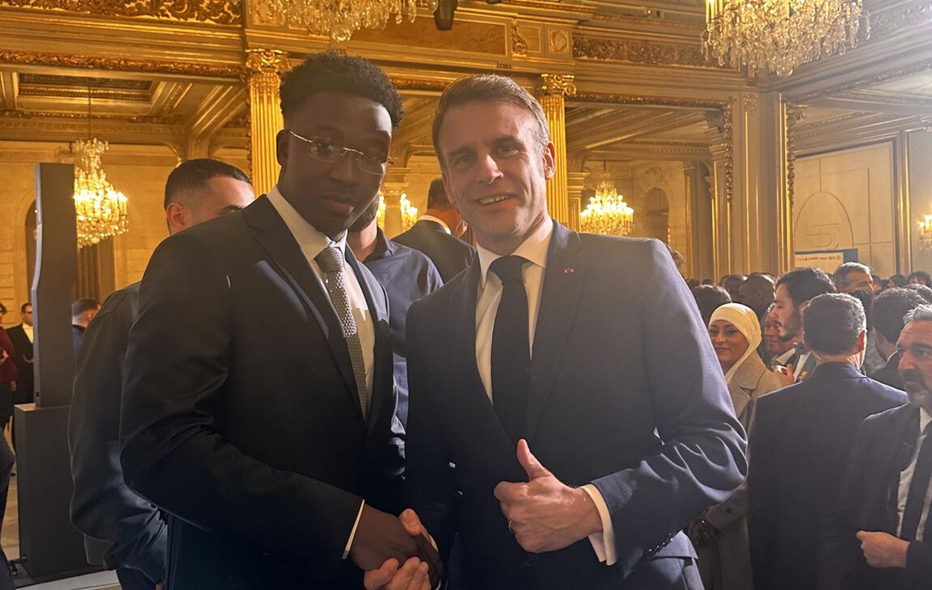 Mbemba Diaby, young diaspora entrepreneur and founder of Just Work, receiving recognition at the Talents des Cités competition. whith president emanuel macron