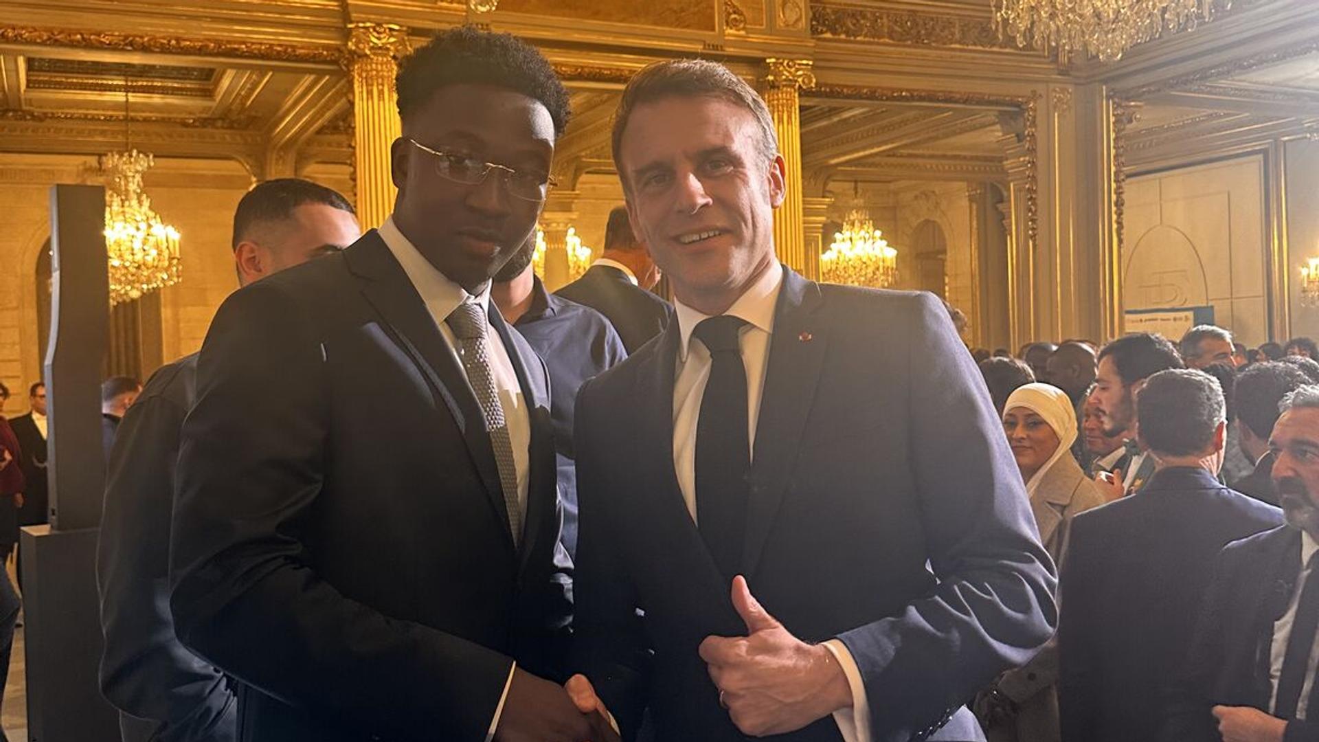Mbemba Diaby, young diaspora entrepreneur and founder of Just Work, receiving recognition at the Talents des Cités competition. whith president emanuel macron