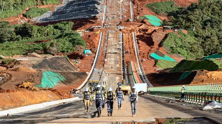 Grues et engins de chantier en pleine activité sur une infrastructure majeure du programme Simandou 2040 en Guinée.
