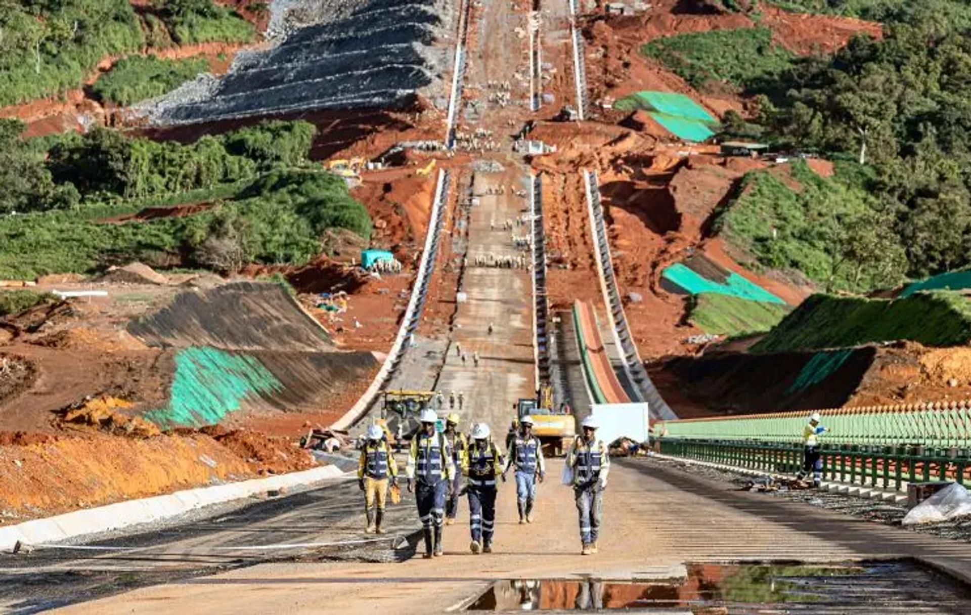 Construction cranes and heavy machinery actively working on a major Simandou 2040 infrastructure site in Guinea.