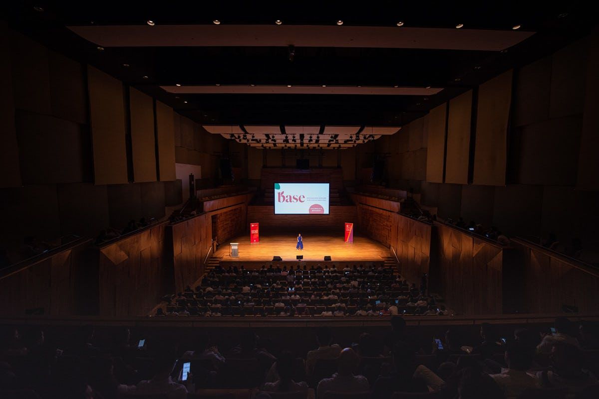 Audience watching Base representative presenting on stage at Singapore Demo Day