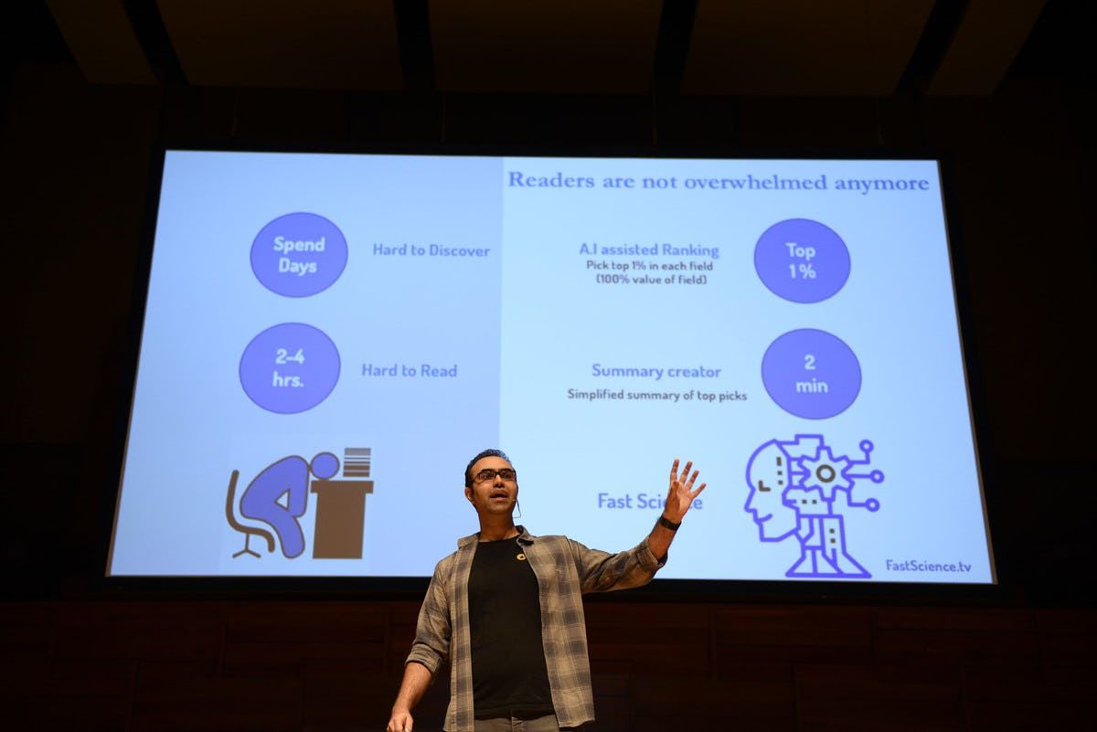 Fast Science representative presenting on stage at Singapore Demo Day with presentation in the background