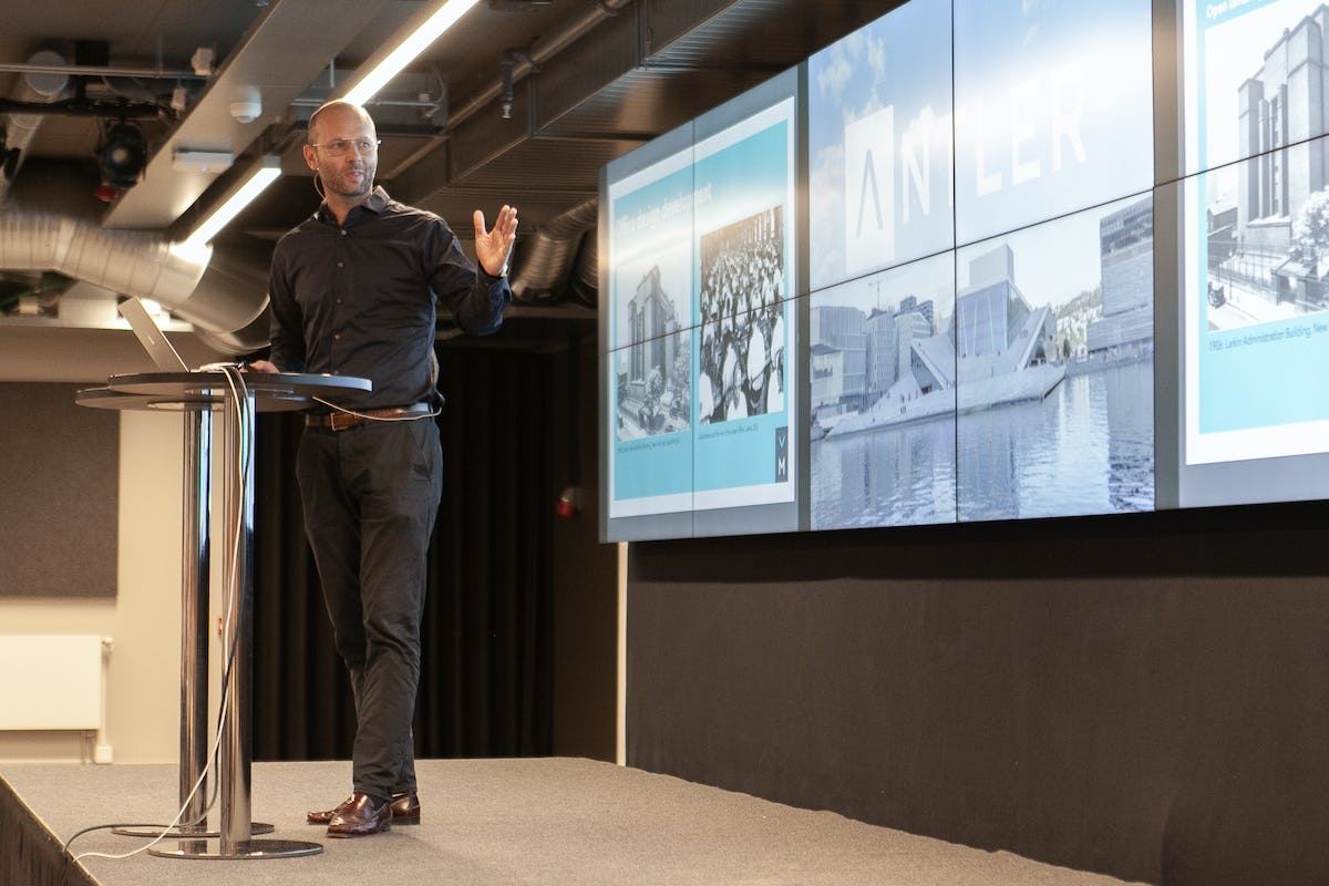 A presenter on stage at an Antler Norway event between corporates and entrepreneurs
