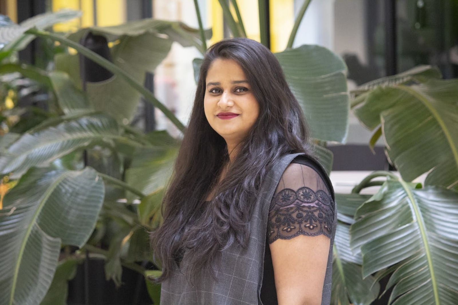 Image of Sneha Das smiling with plants in the background 