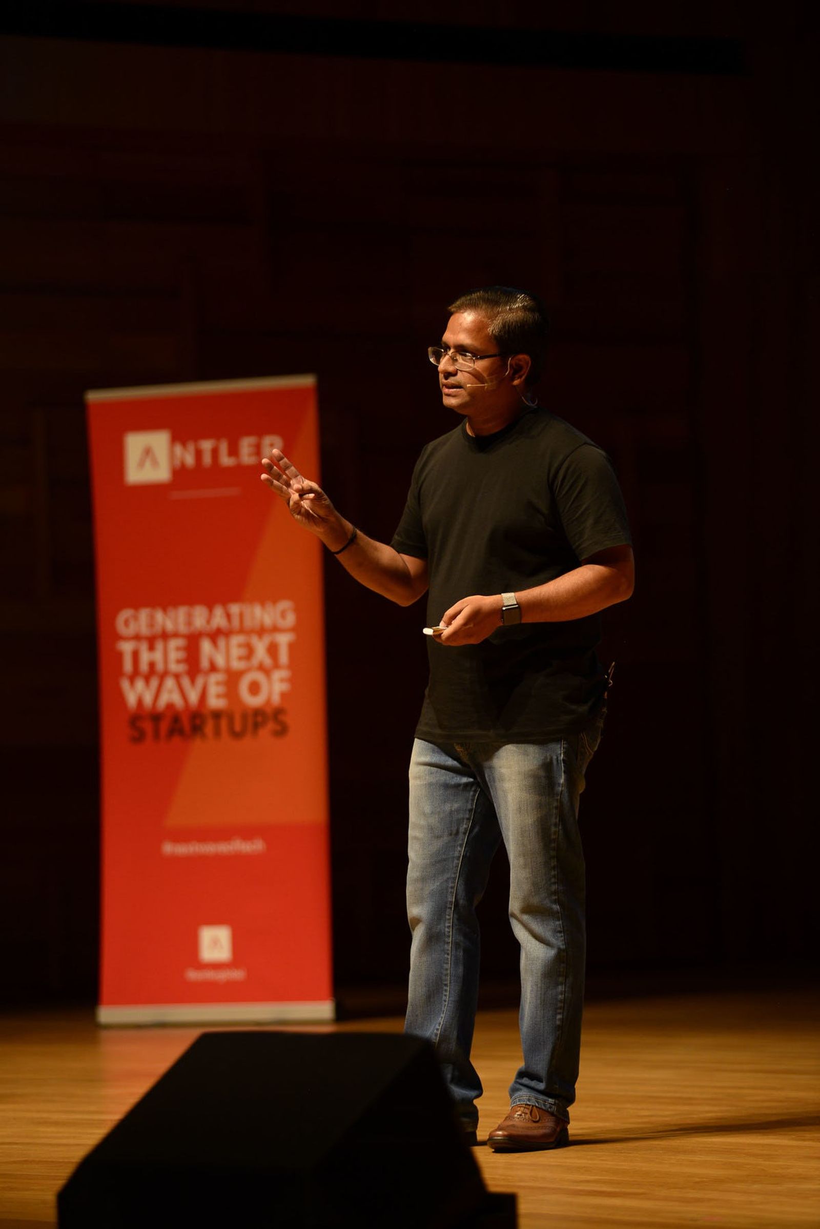 Torre Al representative presenting on stage at Singapore Demo Day with Antler sign in the background 