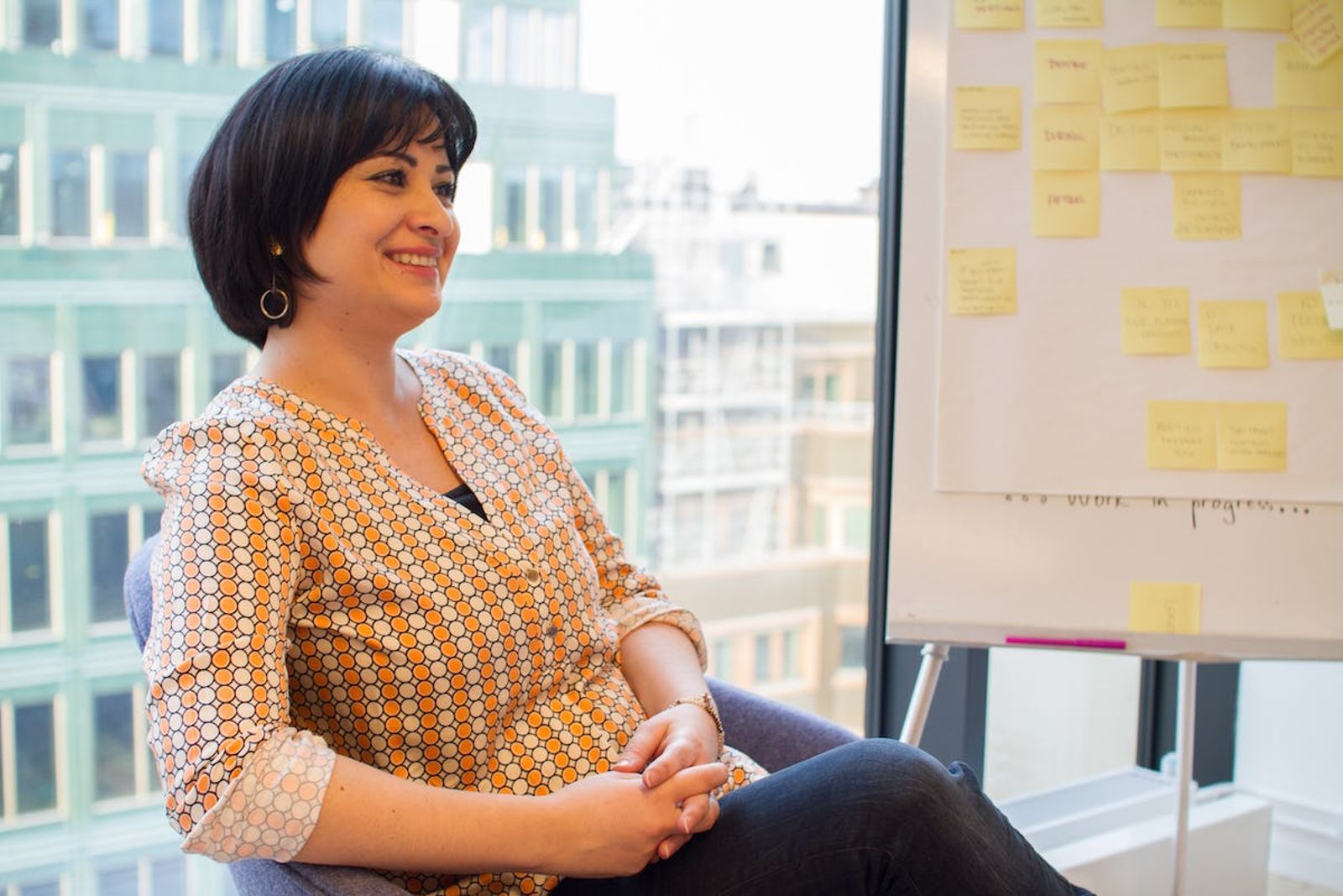 Image of Wala Loubani sitting smiling with whiteboard in back