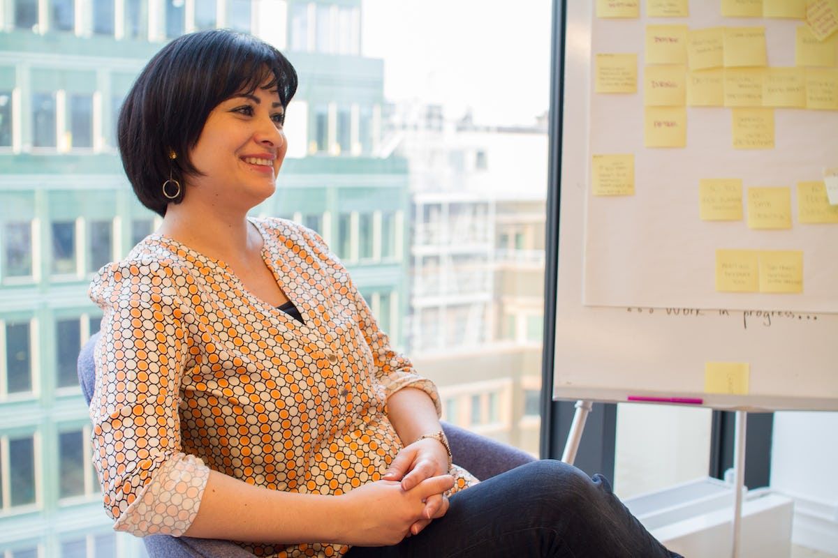 Image of Wala Loubani sitting smiling with whiteboard in back
