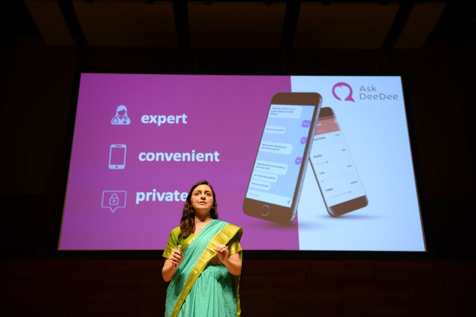 Ask Dee Dee representative presenting on stage at Singapore Demo Day with Ask Dee Dee presentation in the background 
