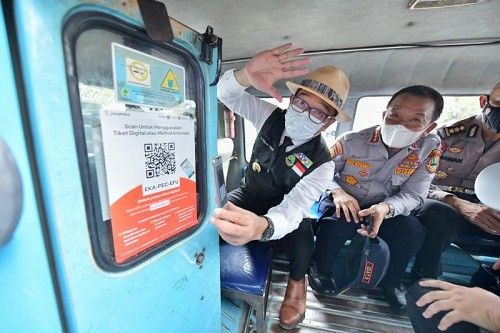 Security waving while sitting inside a vehicle wearing face masks