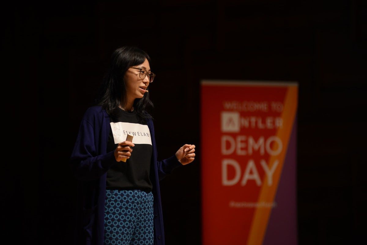 Eskwelabs representative presenting on stage at Singapore Demo Day with Antler sign in the background