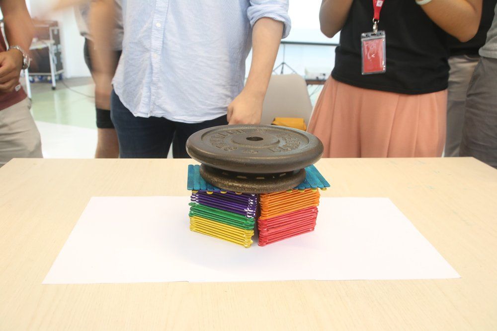 An image of a group's finished ice block stick structure supporting a weighted plate