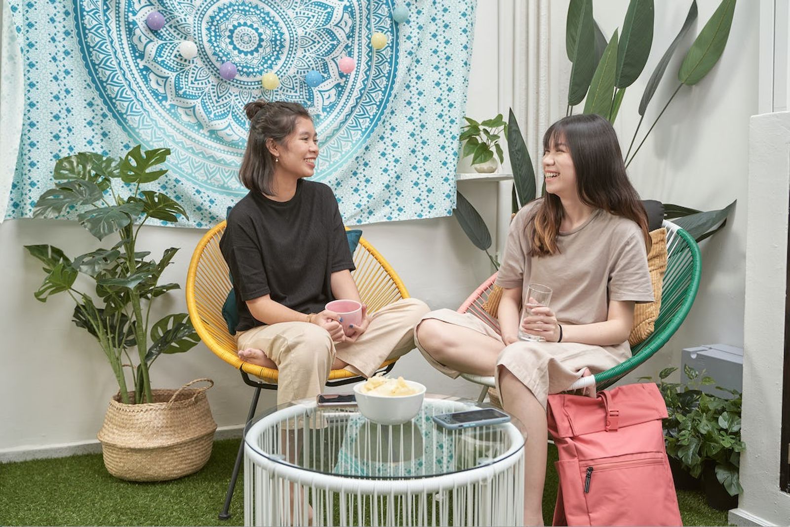 Two women sitting in chairs having a discussion and smiling 