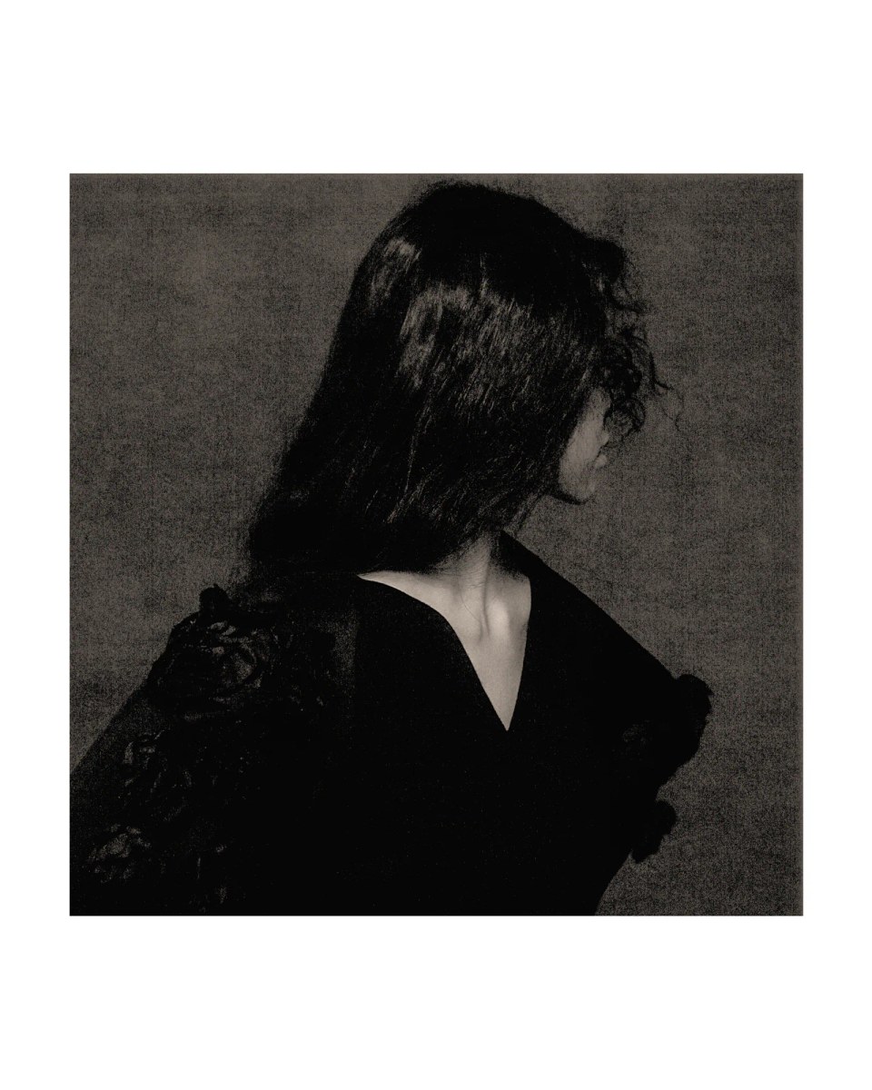 Side-profile portrait of Sammi Chen in black within a white border.