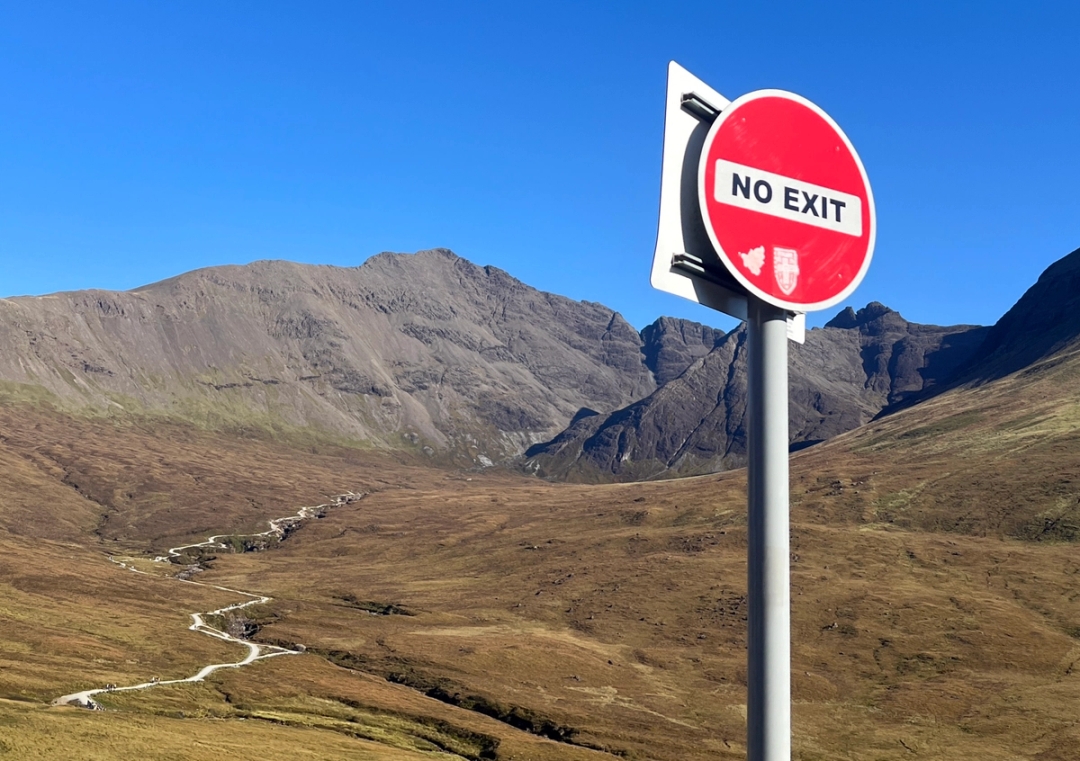 A landscape of the Fairy Pools in Scotland and a "No Exit" sign