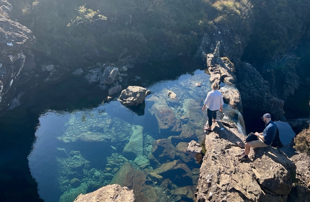 a couple standing by a beautiful pool of water