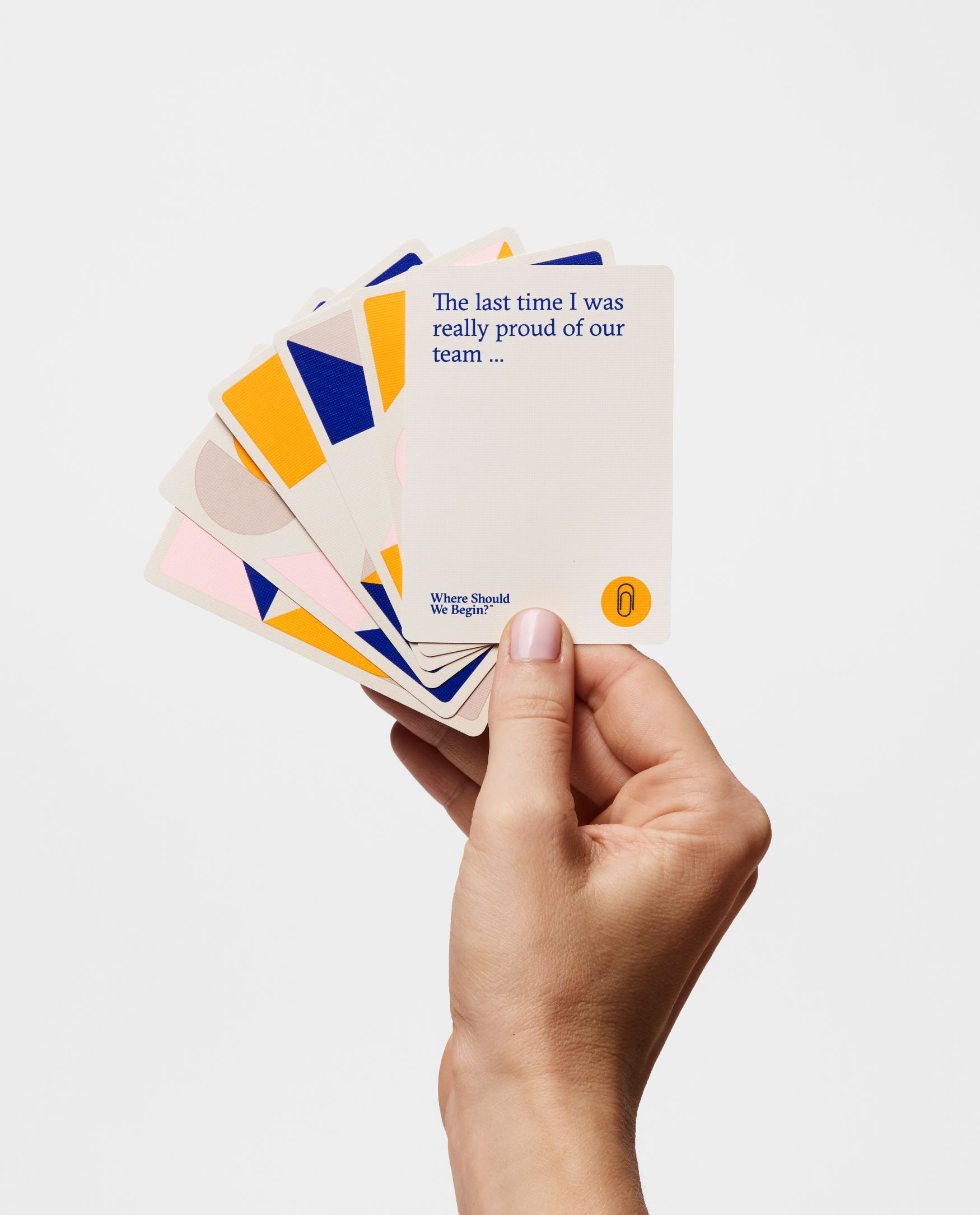 A hand holding a set of cards, the first which reads: "The last time I was really proud of our team..."