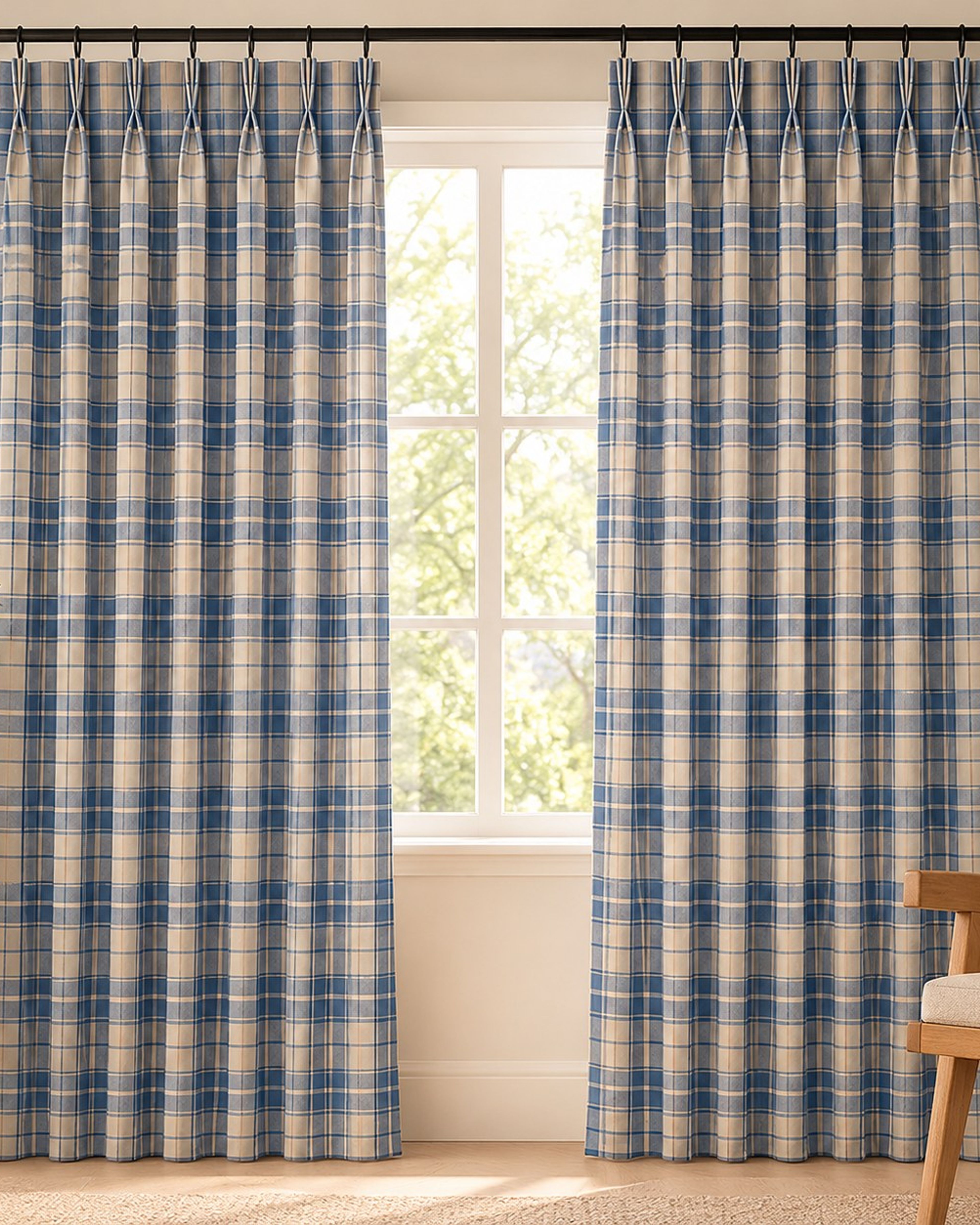 Blue gingham pinch pleat curtains hanging at a bright window