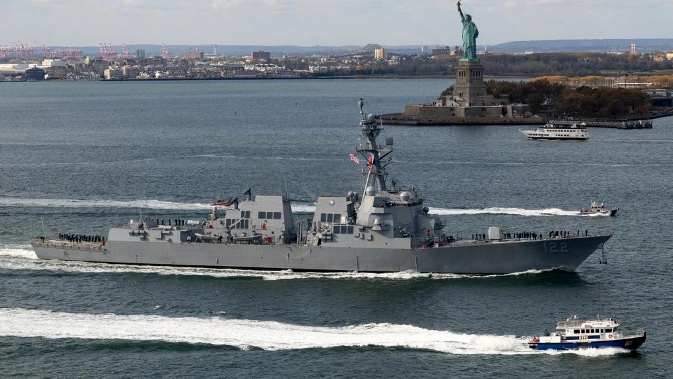 The crew of the Navy’s newest Arleigh Burke-class guided-missile destroyer USS John Basilone (DDG 122) mans the rails as the USS John Basilone sails past the Statue of Liberty for its commissioning ceremony week in New York City Nov. 4, 2024.