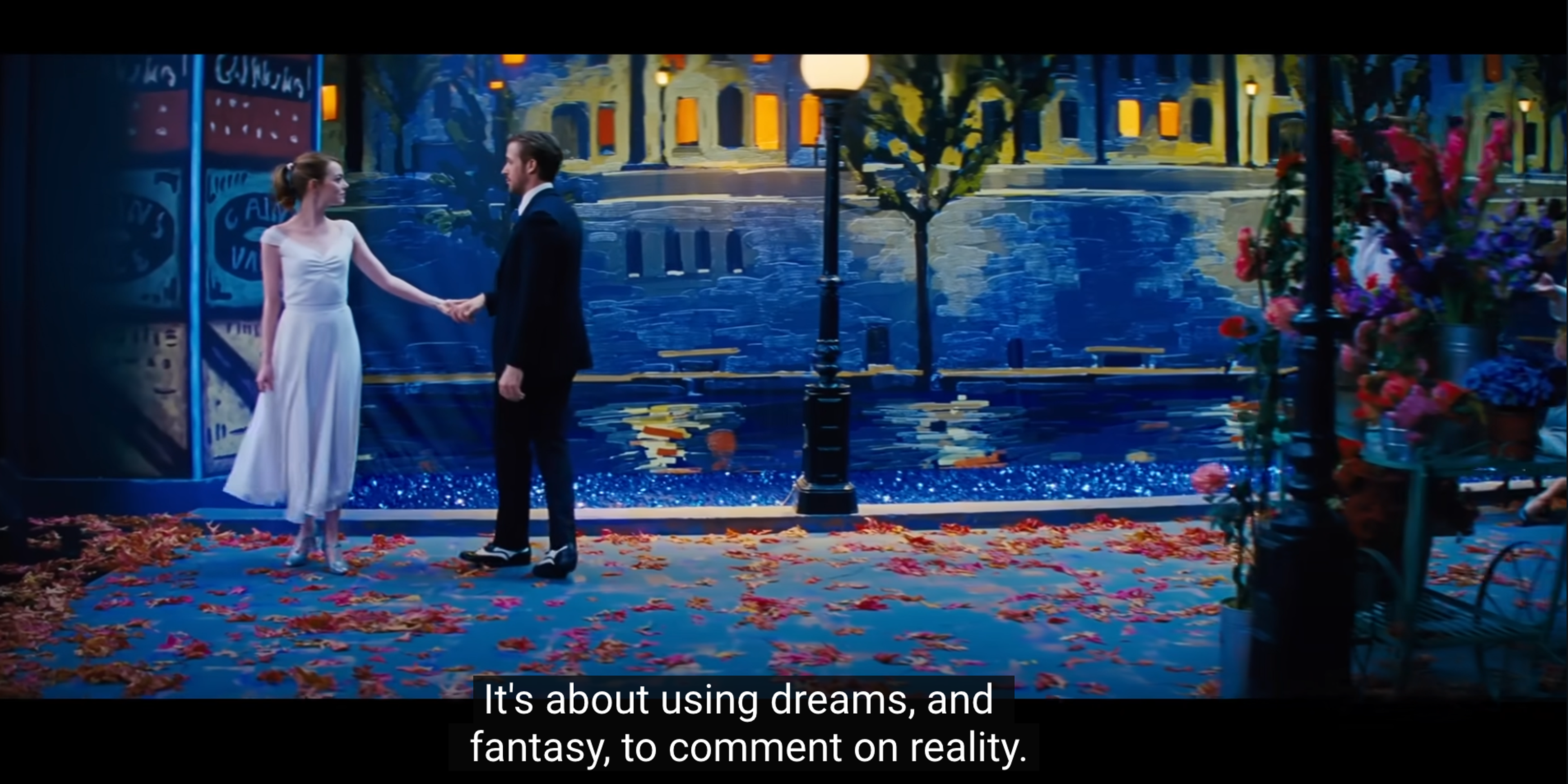 a man and woman holding hands in front of a painting that says it 's about using dreams and fantasy to comment on reality