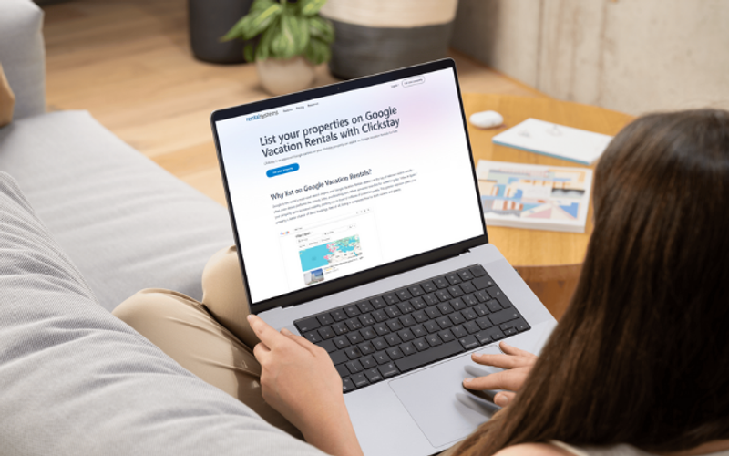 Woman looking at the Rentalsystems pages on her laptop, learning about how to list on Google Vacation Rentals via Clickstay