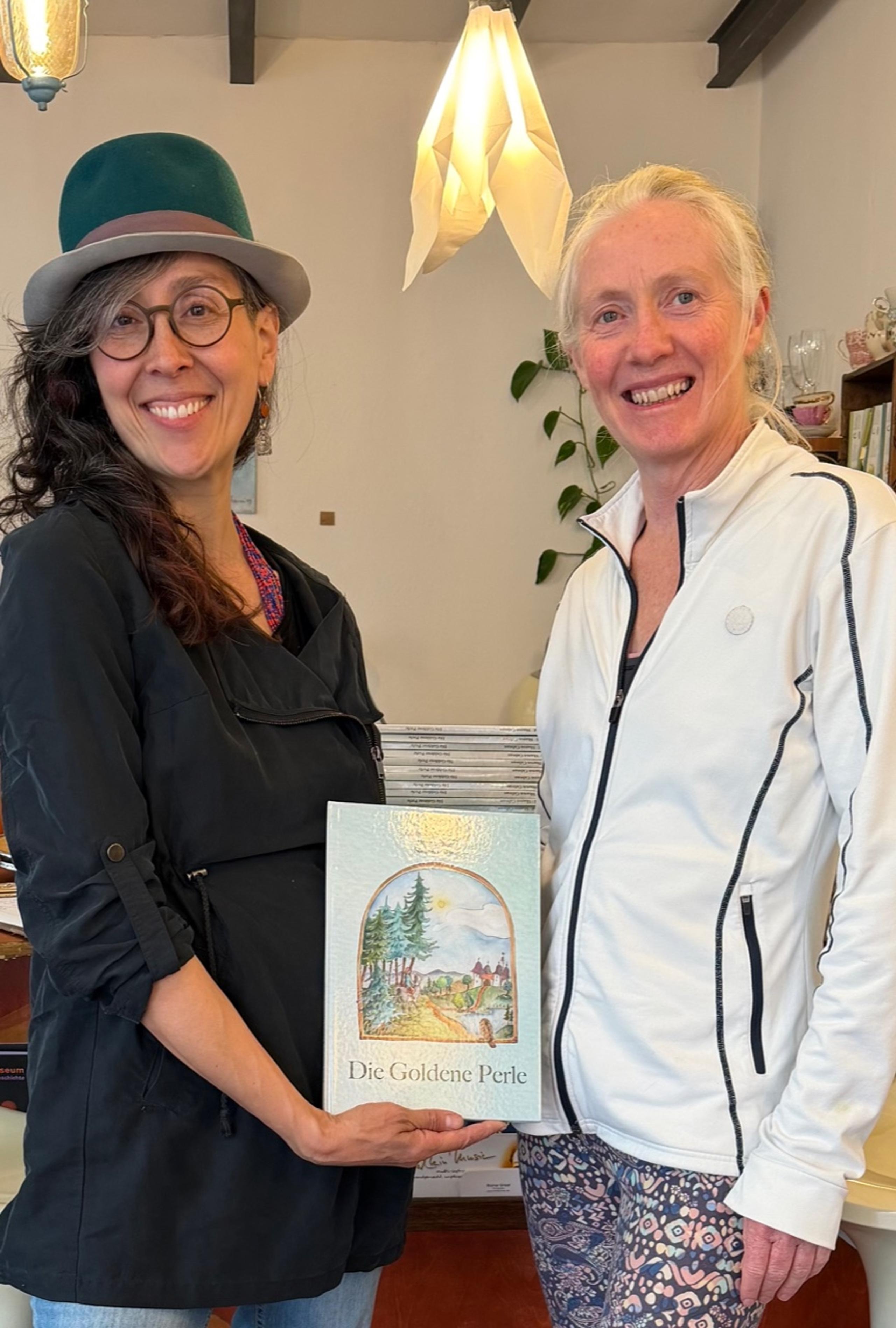 Zwei Frauen präsentieren das Buch „Die Goldene Perle“ in der Galerie Las Comadres.