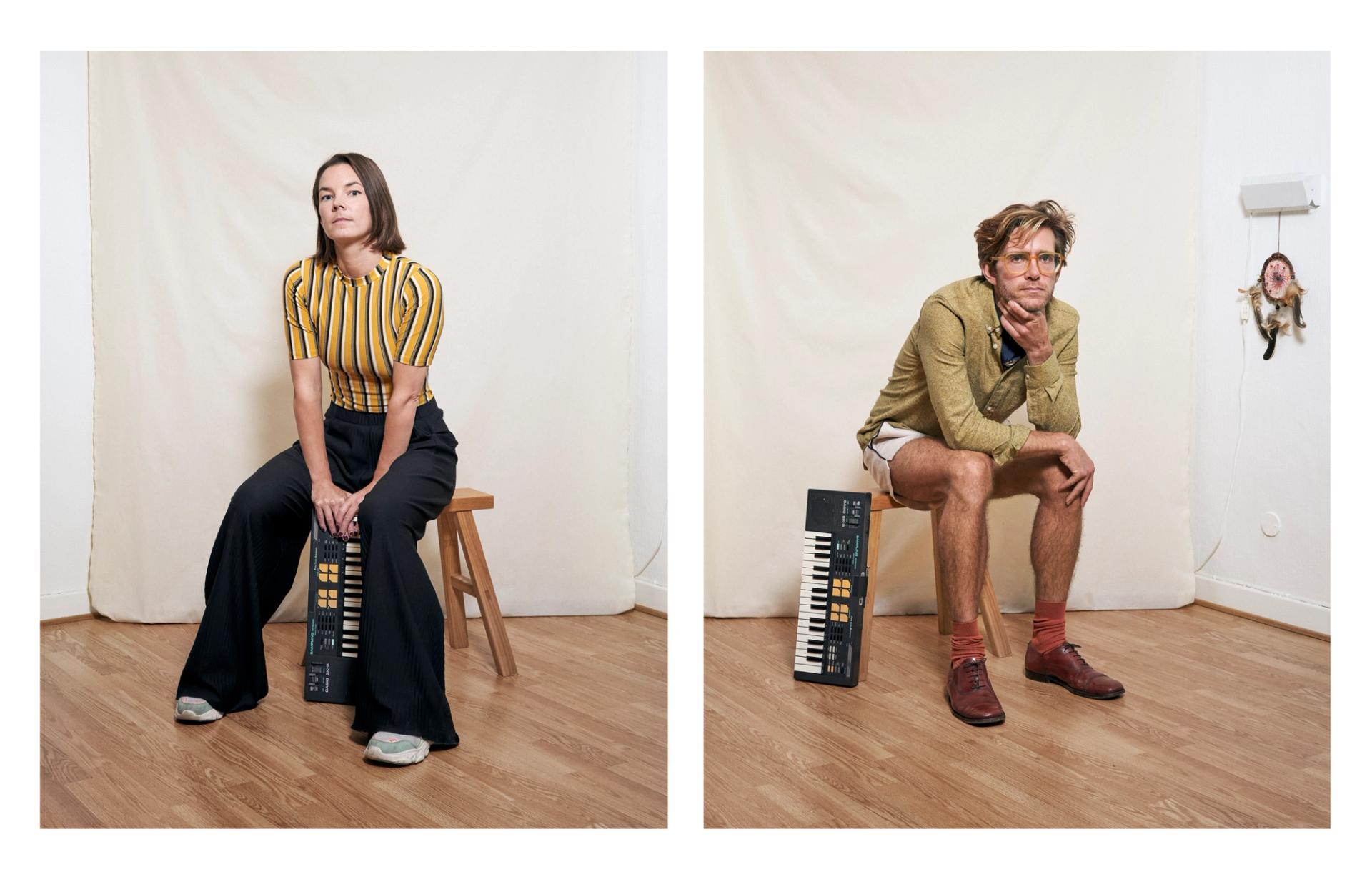 Ingrid and Lasse are sitting on a wooden stool, each with a casio-keyboard, in a white room in front of an off-white canvas. They look straight in the camera.