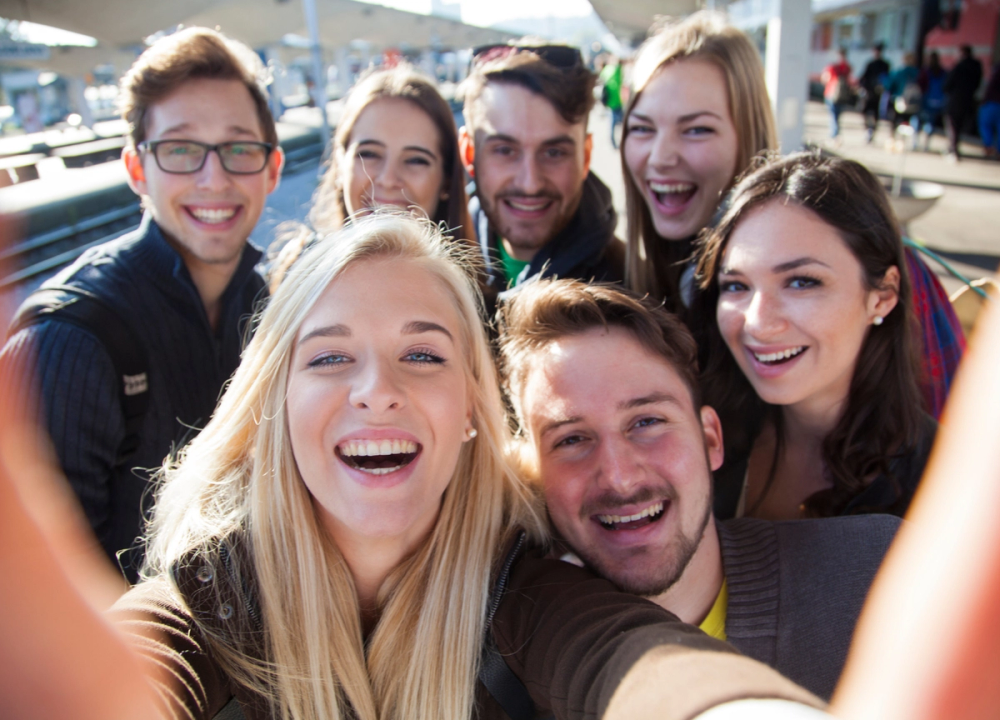 group of happy teens taking a selfie