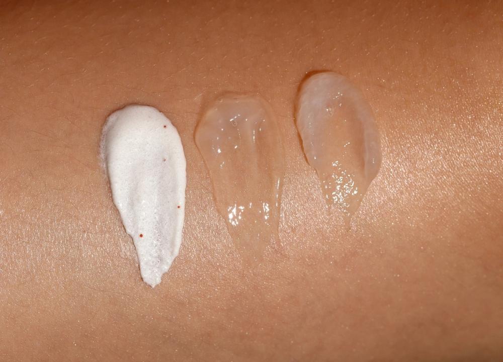 three swipes of different creams on a person's arm
