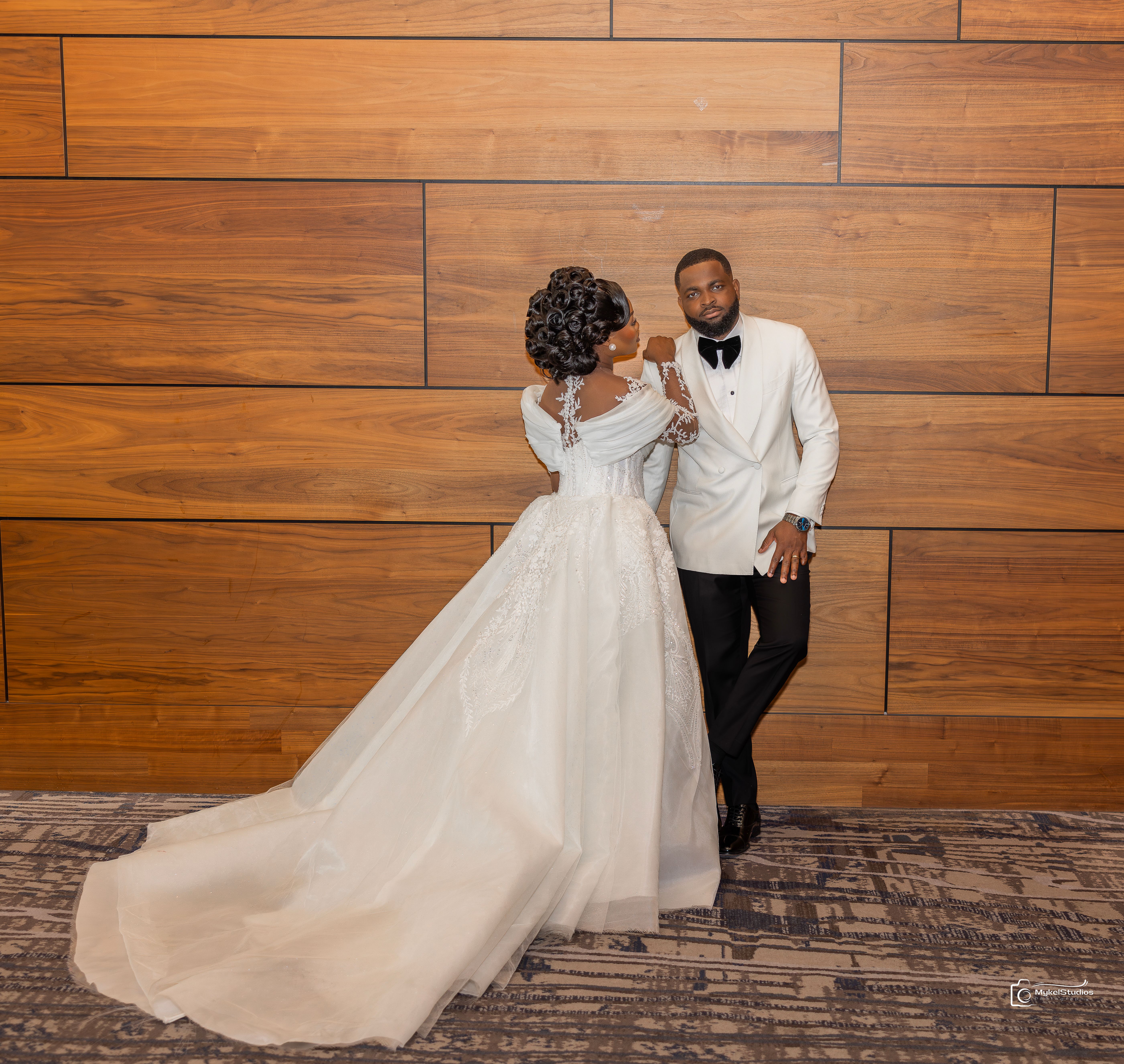 Bride and groom infront of a wooden wall
